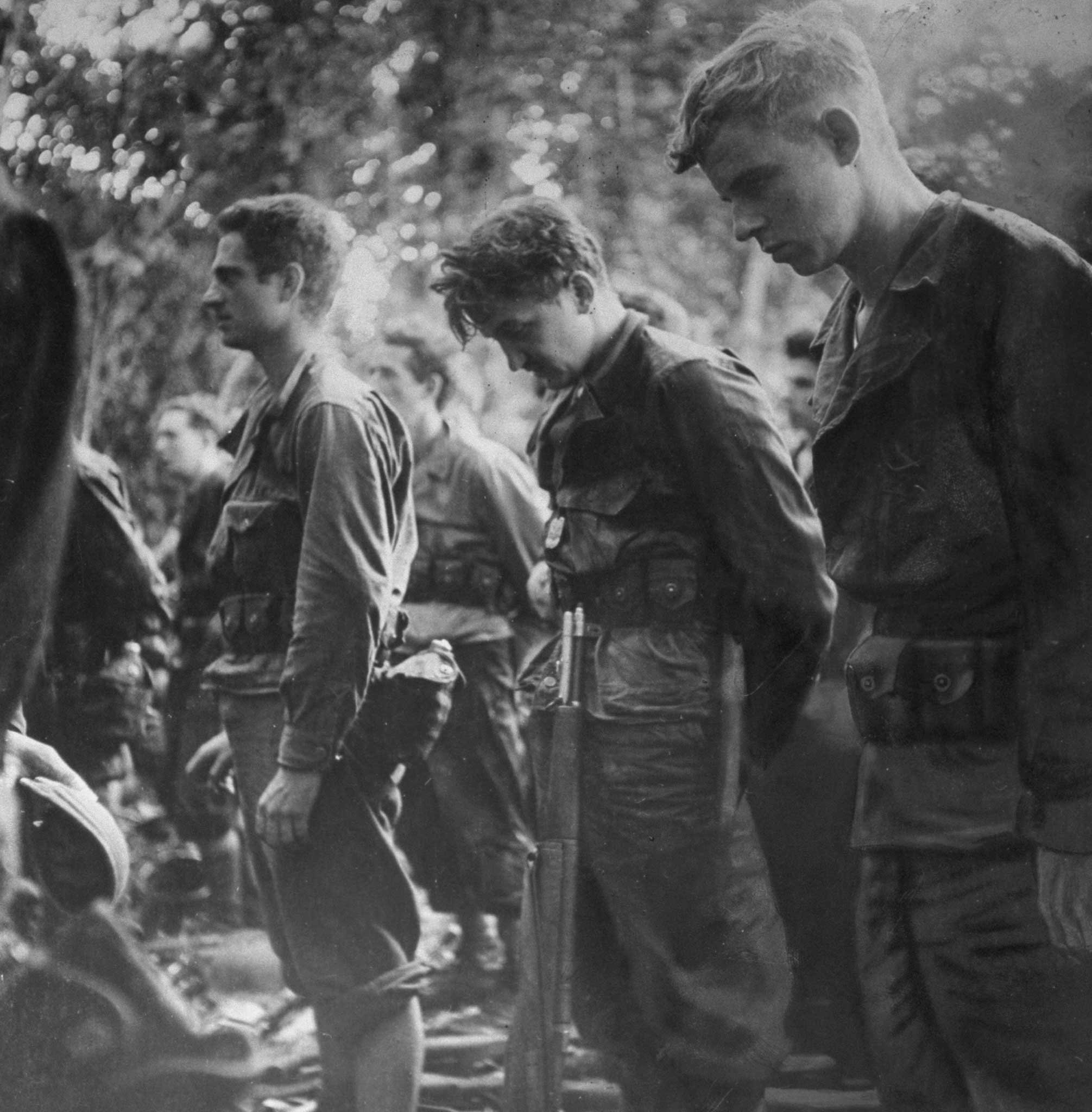 "At church service soldiers who have just captured Buna Village look straight ahead or bow their heads in prayer. Said Captain Boice, their commander: 'This is not the first time Americans have carried guns to church and it will not be the last.' Later Captain Boice was killed."