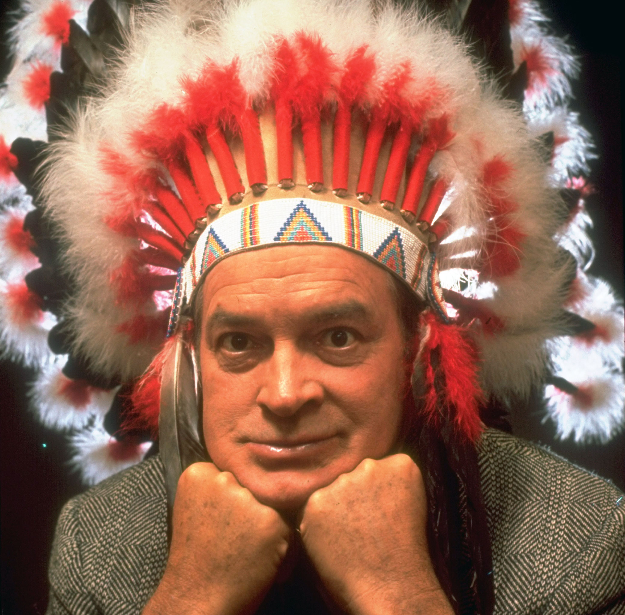 Bob Hope posing in a Native American headdress presented to him by Oklahoma State University, 1962.