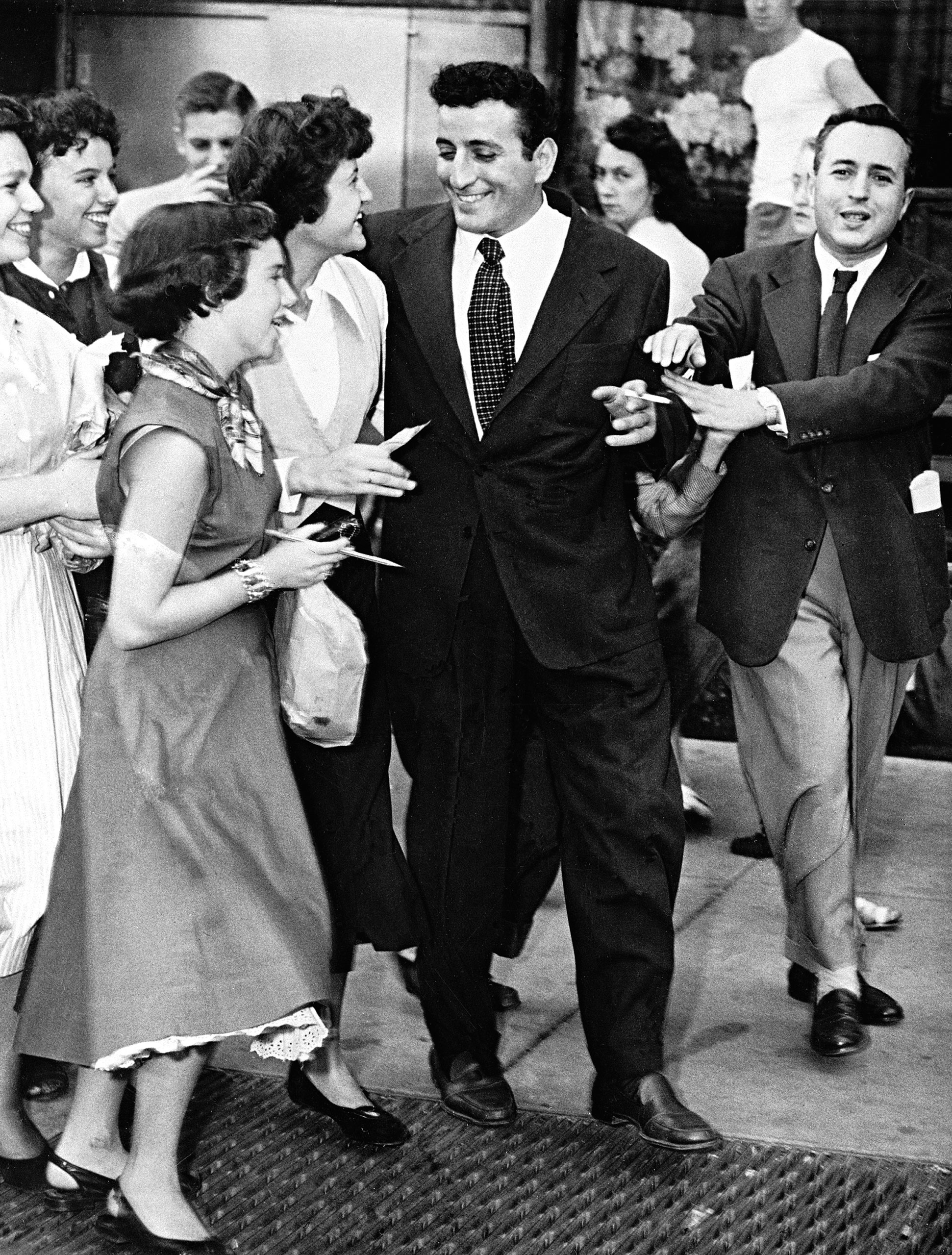 Singer Tony Bennett is approached by autograph seekers as he leaves a performance on Oct. 4, 1951.