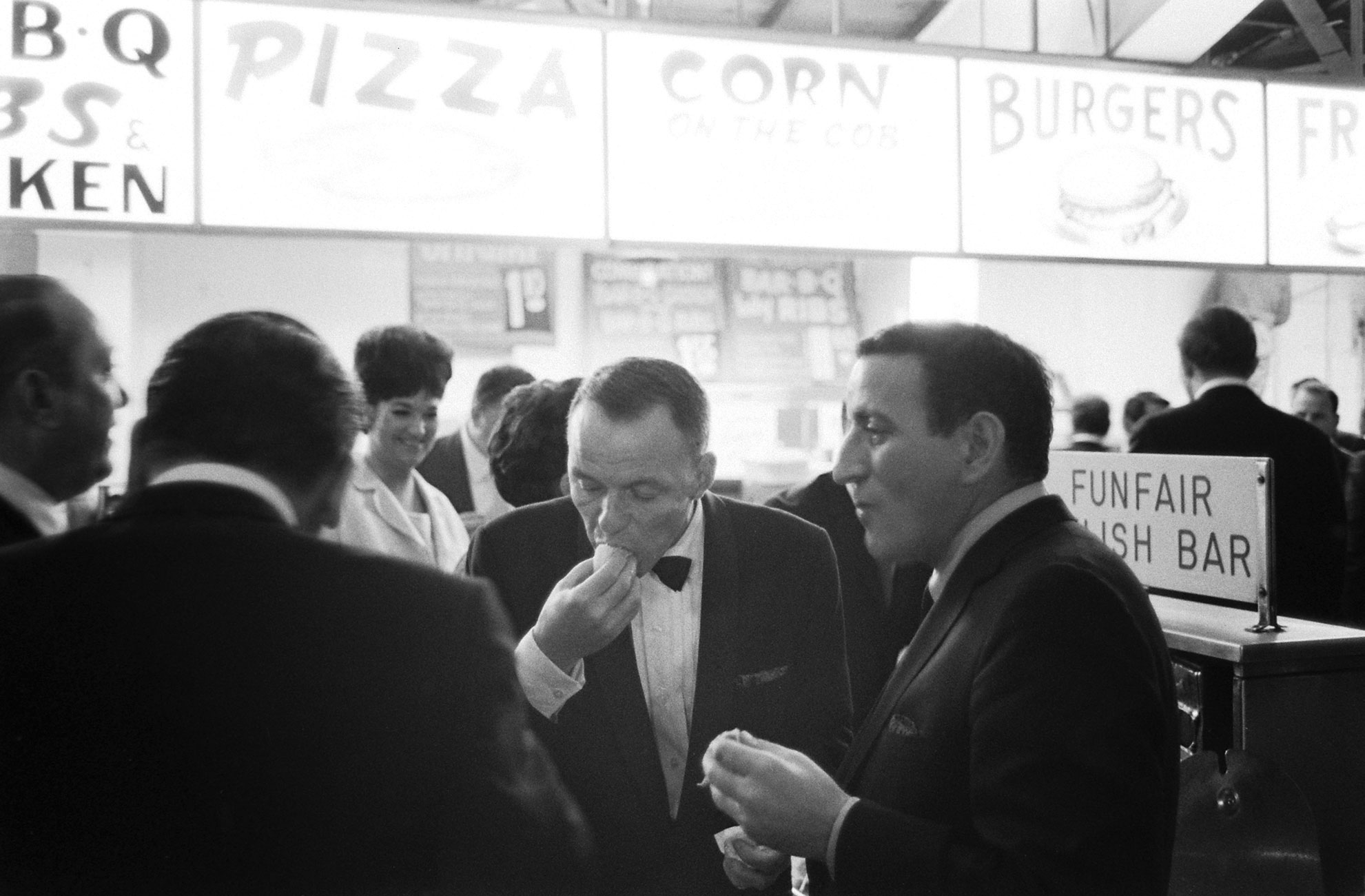 Tony Bennett, Frank Sinatra and friends eat some late-night hot dogs, Miami, 1965.