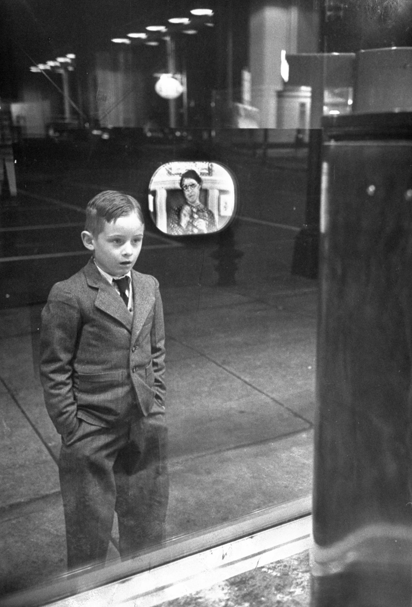 A boy watches TV in an appliance store window in 1948.