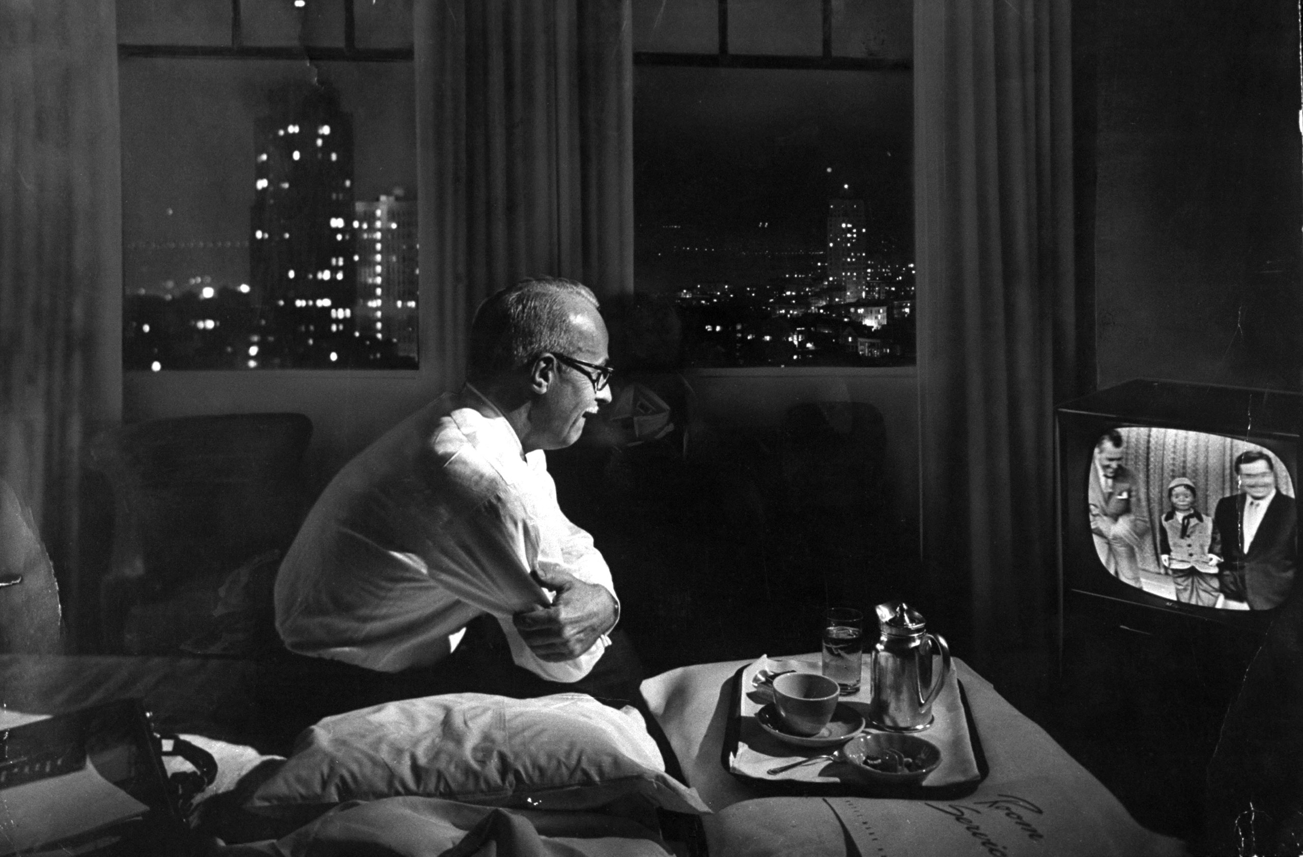 A traveling businessman watches TV in a hotel room in 1958.