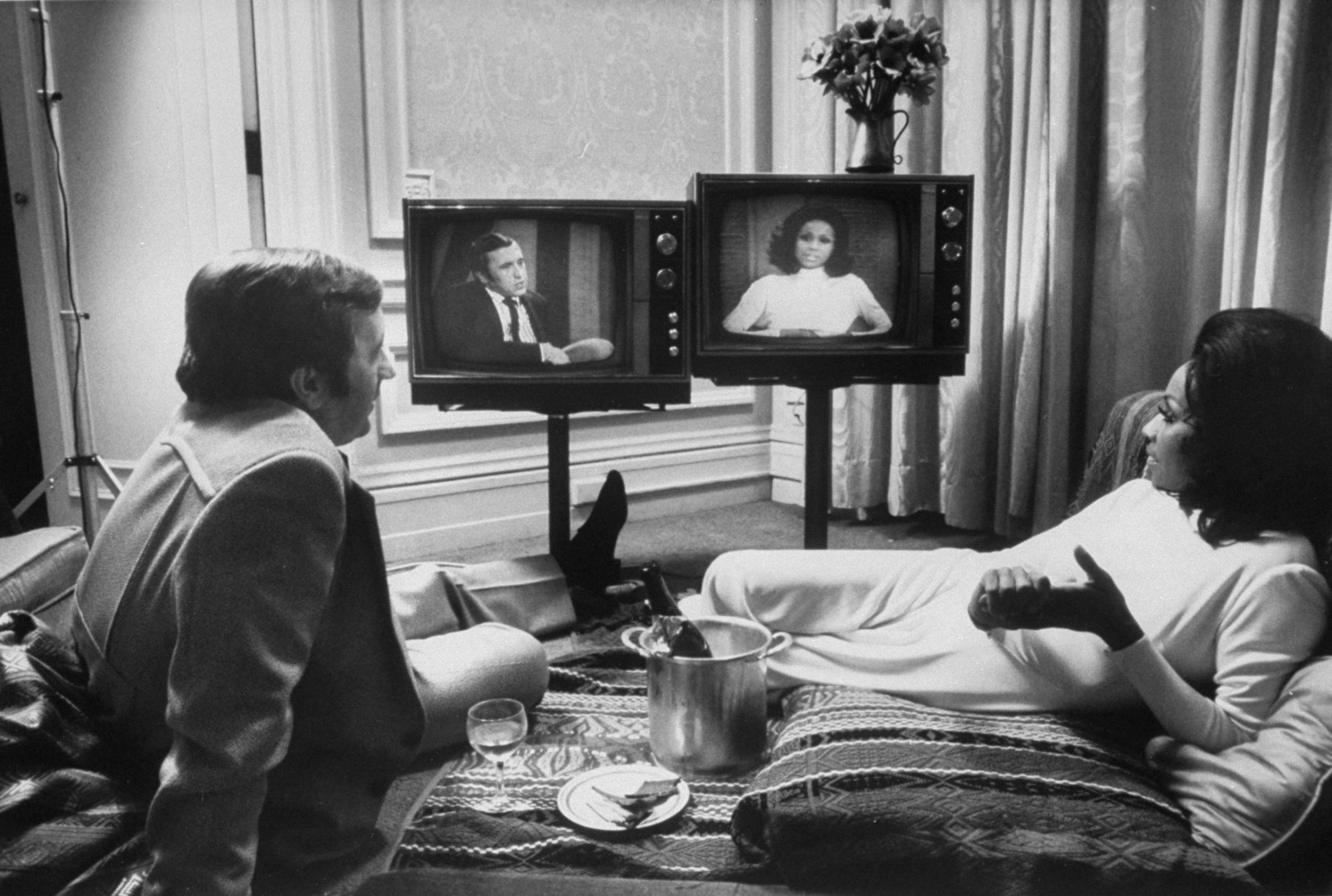 Actress Diahann Carroll and journalist David Frost watch themselves on separate talk shows. Carroll and Frost were engaged for a while, but never married.