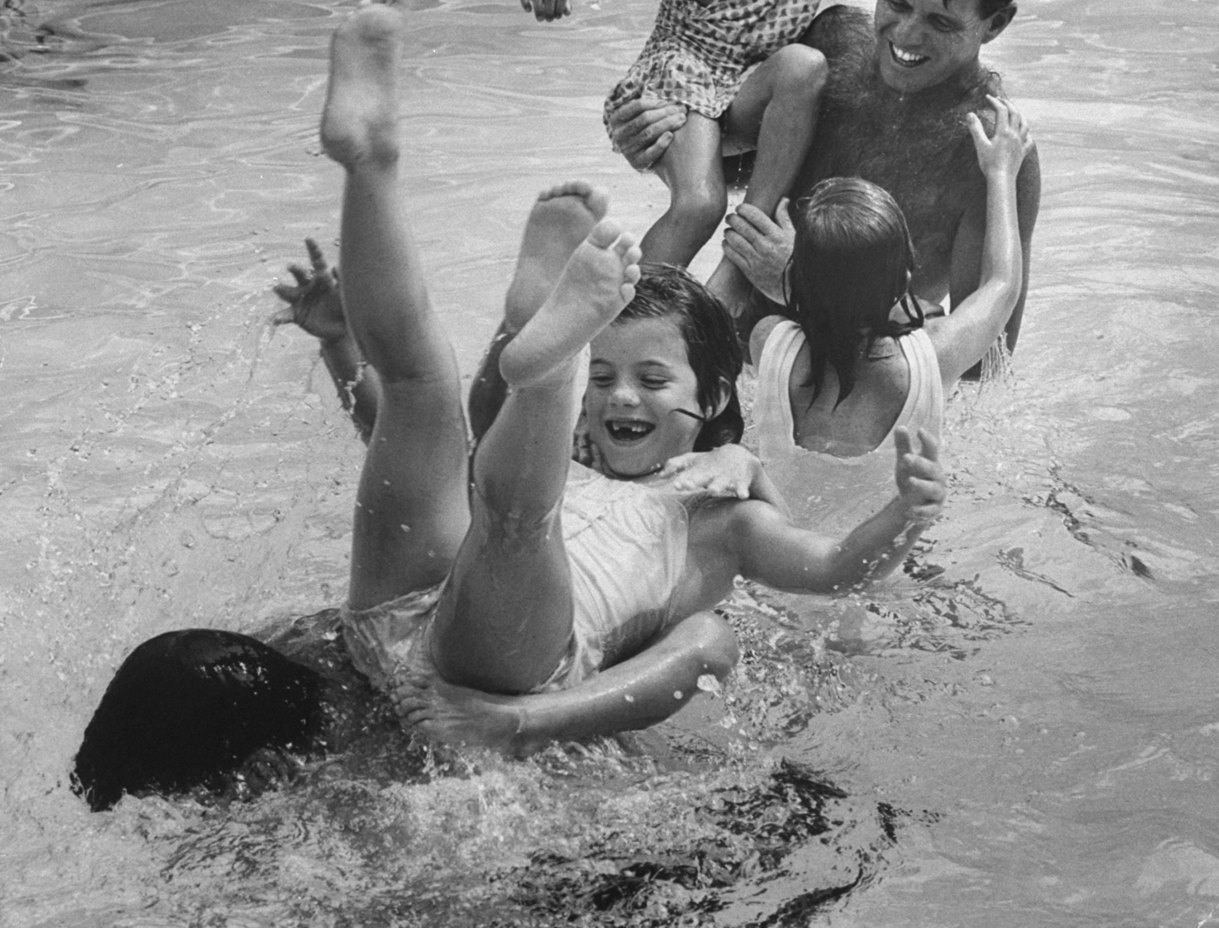 Caroline Kennedy, legs tangled in a cousin's, tumbles off a submerged Pierre Salinger. They lost a watery jousting match with Bob and two of his daughters.