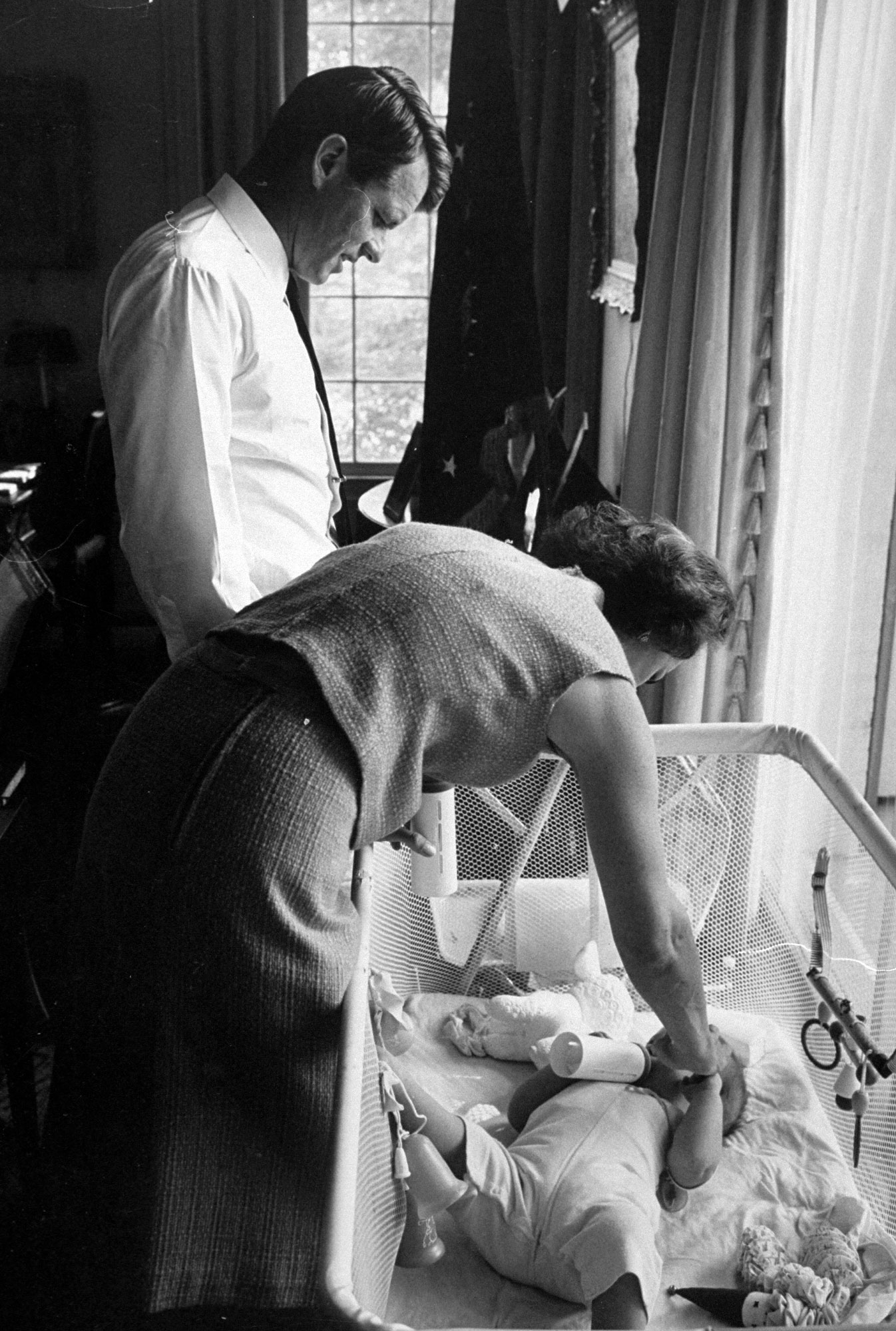 Robert F. Kennedy and his wife Ethel putting their one-year-old son, Christopher, down for a nap, 1964.