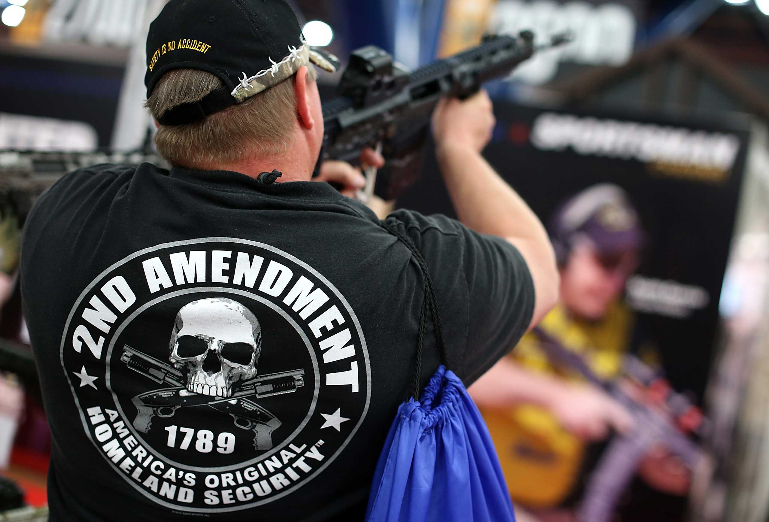 An attendee wears a 2nd amendment shirt while inspecting an assault rifle during the 2013 NRA Annual Meeting and Exhibits at the George R. Brown Convention Center on May 5, 2013 in Houston, Texas. (Justin Sullivan&mdash;Getty Images)