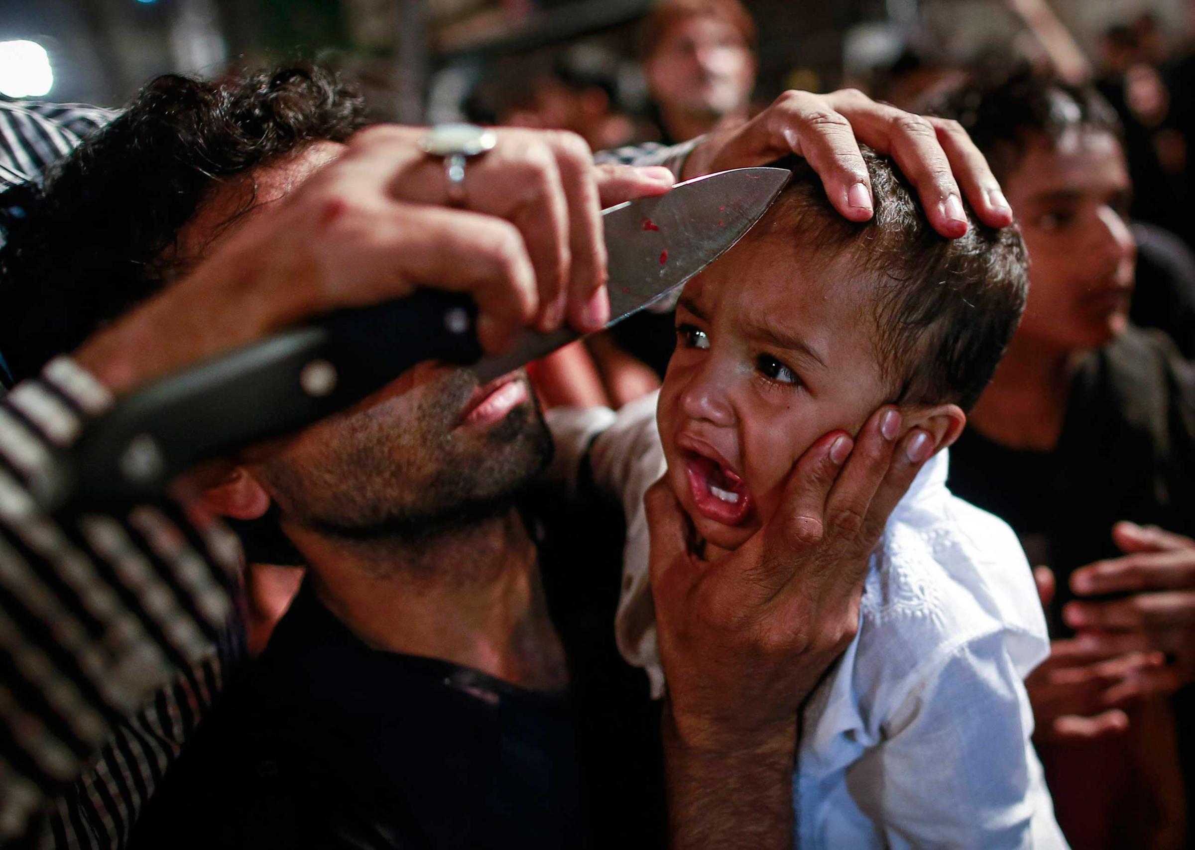 A Shi'ite Muslim has his child gashed with a knife during a Muharram procession ahead of Ashoura in Mumbai