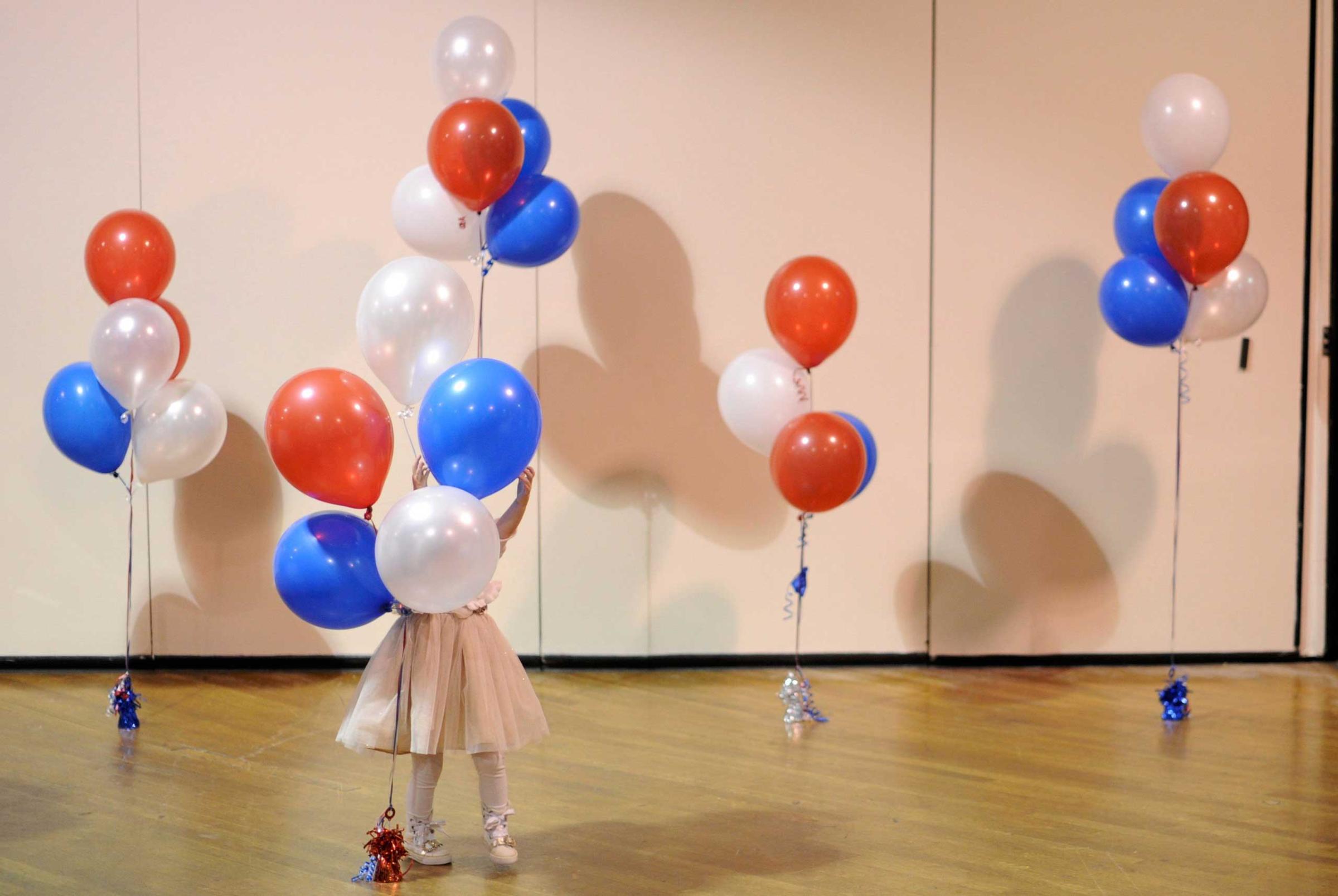 A little girl plays with balloons at Republican U.S. Senate candidate Scott Brown's midterm election night rally in Manchester
