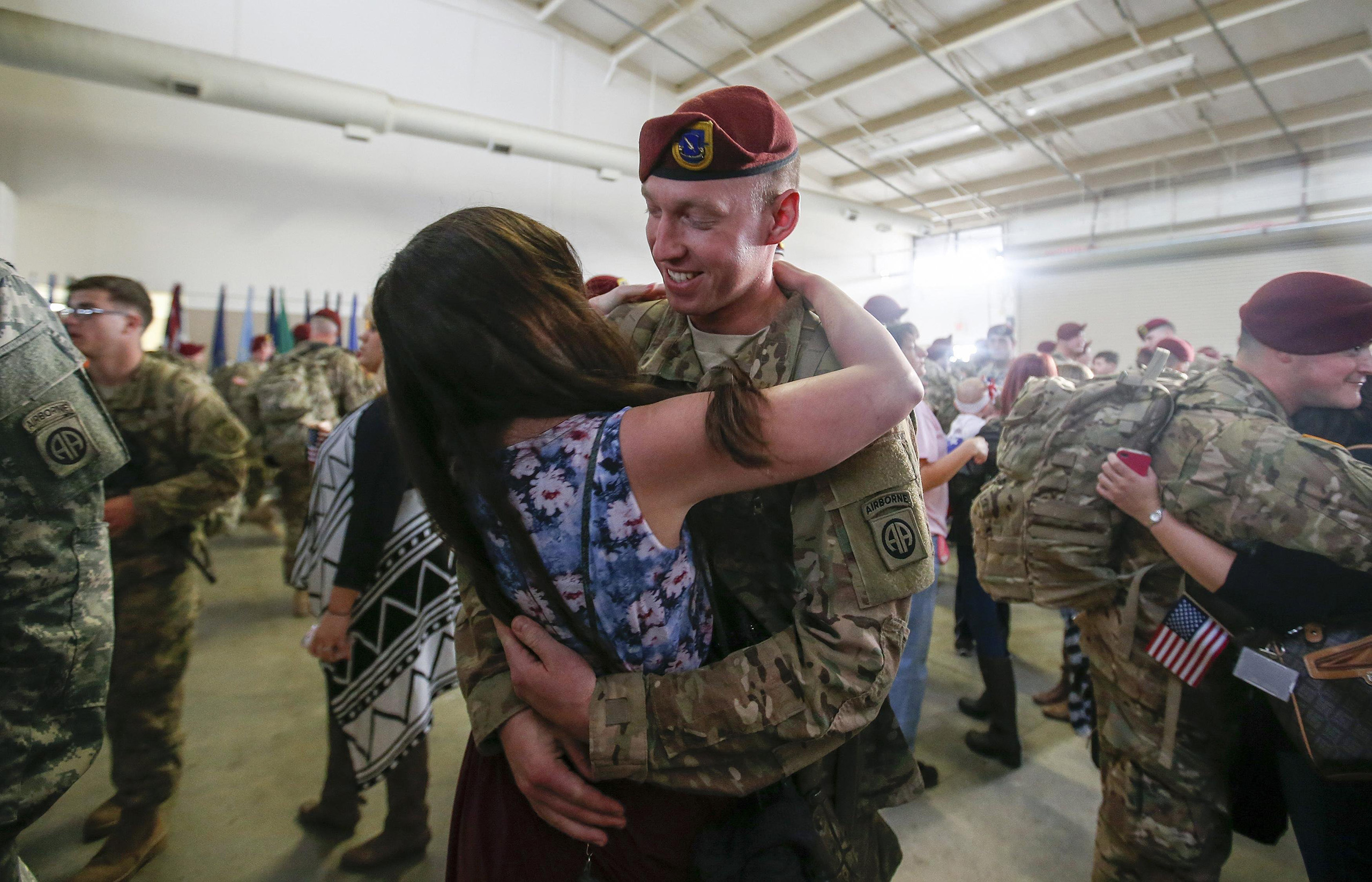 A paratrooper with the 1st Brigade Combat Team, 82nd Airborne Division, hugs his wife after returning home from Afghanistan at Pope Army Airfield in Fort Bragg, North Carolina on Nov. 5, 2014.