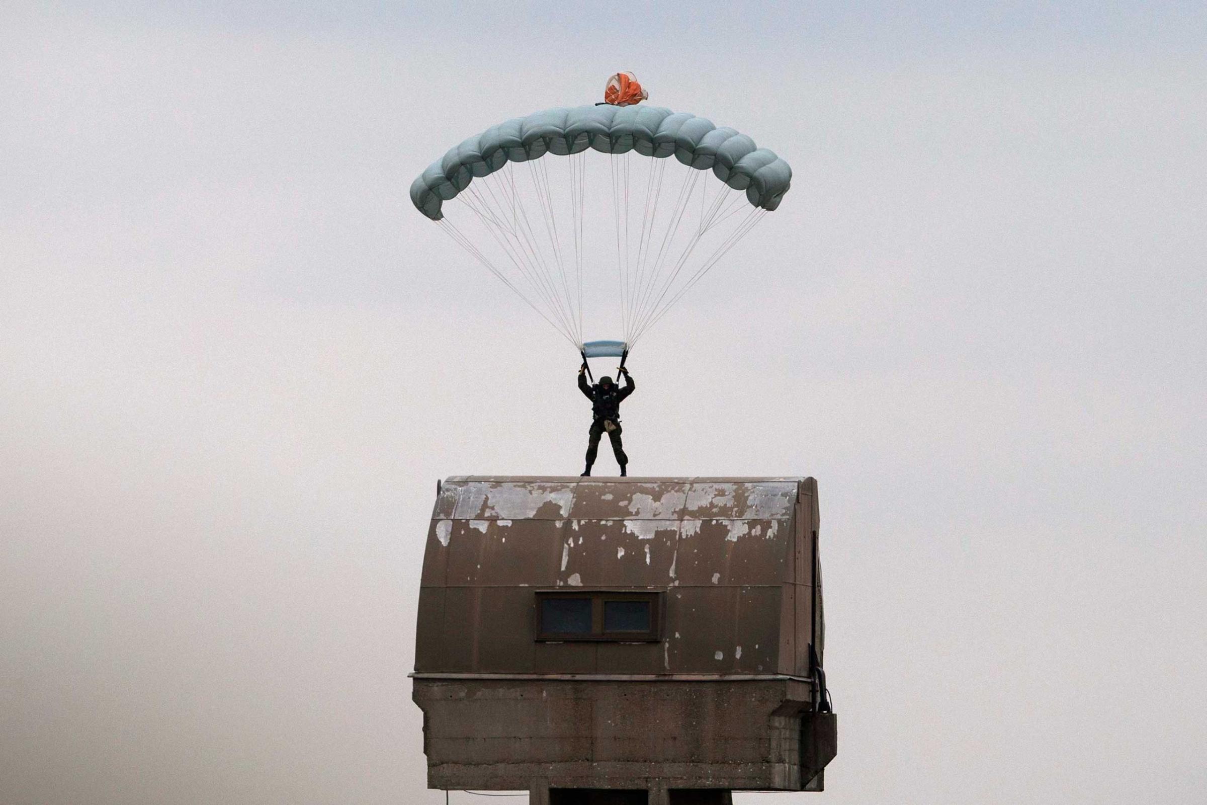 A Russian paratrooper descends to the ground during a training exercise in the village of Nikinci