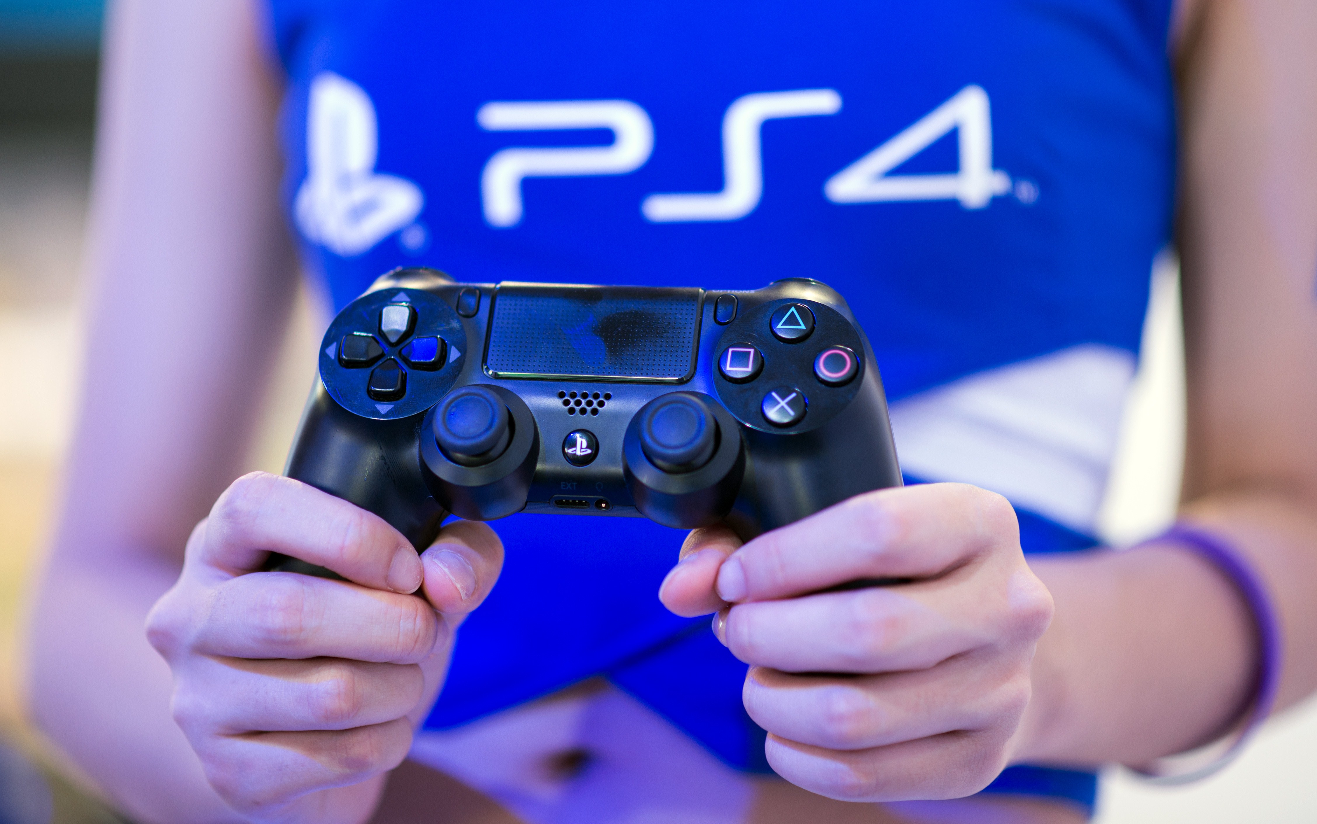 A hostess holds a remote of a  Playstation 4 at the Sony booth during the China Joy fair in Shanghai on July 31, 2014. (Johannes Eisele&mdash;AFP/Getty Images)