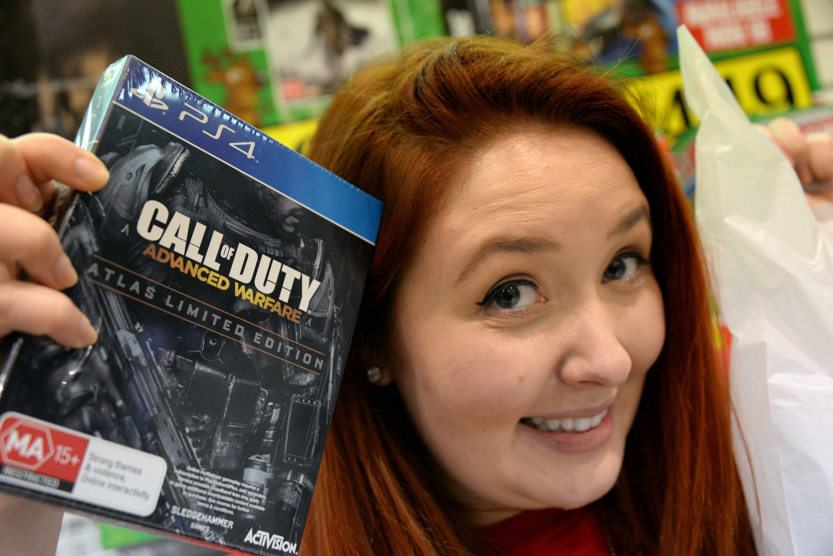 A shopper poses with the newest instalment of the "Call of Duty" videogame at a midnight launch of per-ordered copies of the game in Sydney on Nov. 3, 2014. (Saeed Khan—AFP/Getty Images)