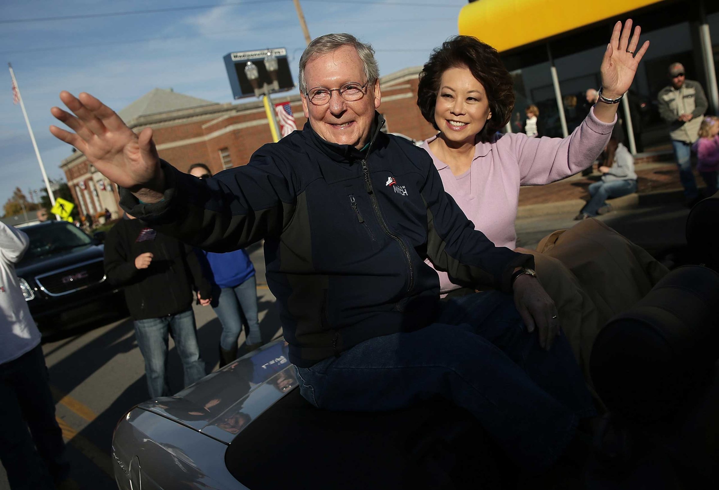 Senate Minority Leader Mitch McConnell (R-KY) waves while riding with his wife Elaine Chao (R) in the Hopkins Country Veterans Day Parade on November 2, 2014 in Madisonville, Ky.