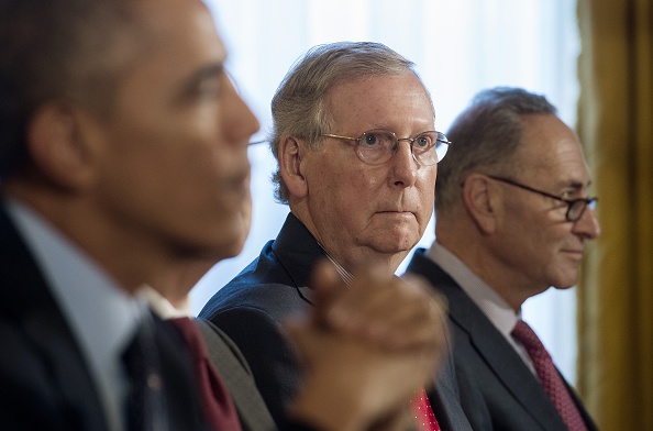 Mitch McConnell, R-Kentucky, center, looks on as U.S. President Barack Obama, left, speaks during a bipartisan, bicameral congressional leadership luncheon at the White House in Washington, D.C., Nov. 7, 2014 (Jim Watson—AFP/Getty Images)