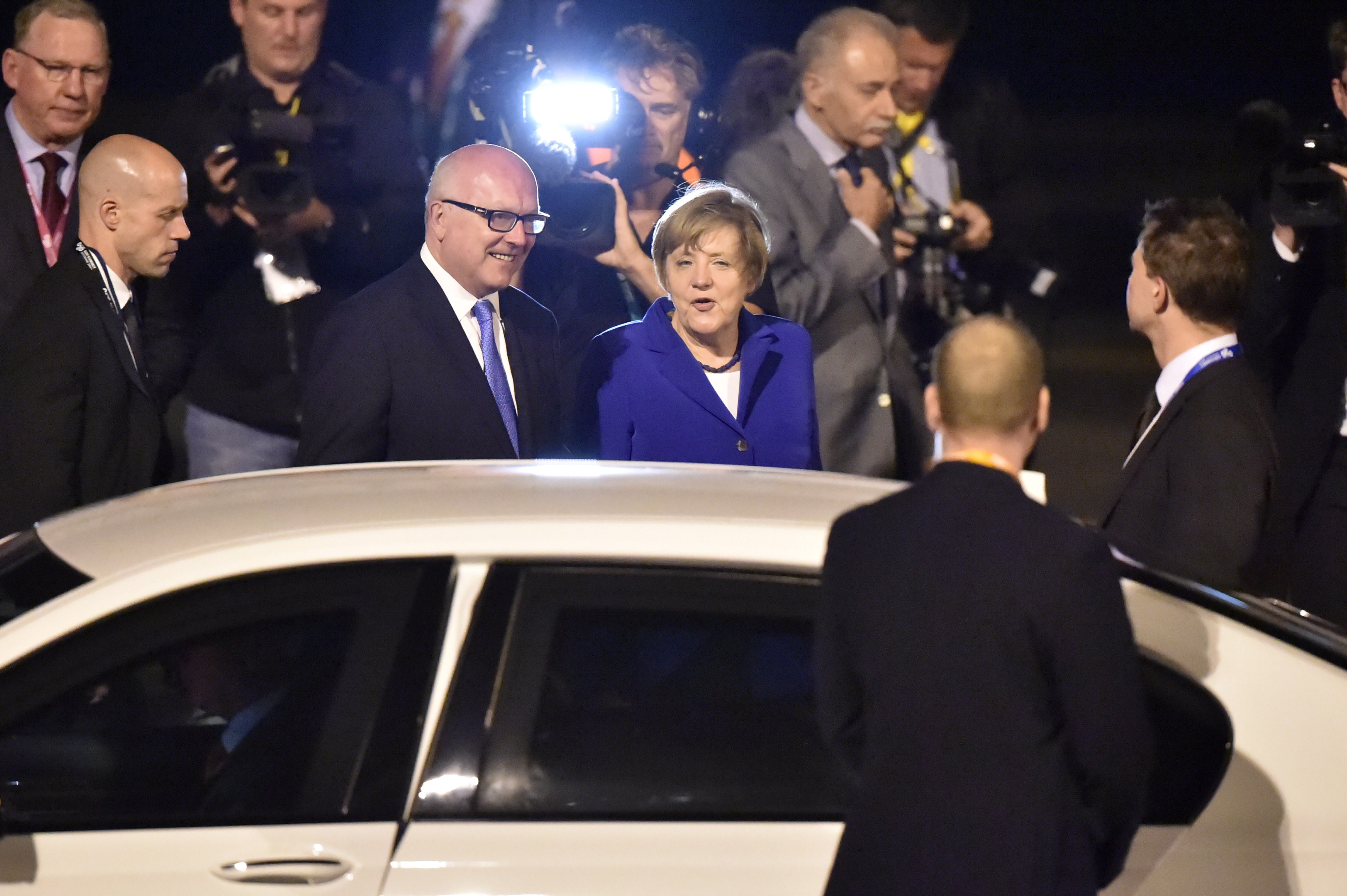 Germany's Chancellor Angela Merkel (C) is welcomed upon her arrival at the airport in Brisbane to take part in the G20 summit on November 14, 2014. (Peter Parks—AFP/Getty Images)