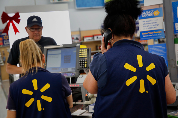 Employees assist shoppers at the check out counter of a Wal-Mart Stores Inc. location ahead of Black Friday in Los Angeles, California, U.S., on Monday, Nov. 24, 2014 (Bloomberg—Getty Images)