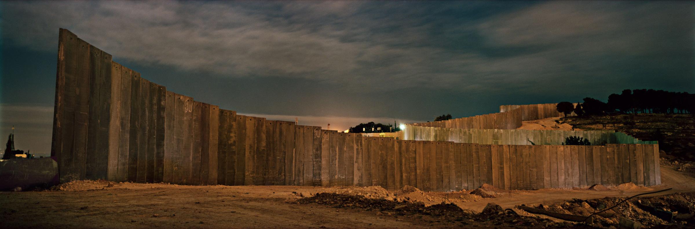 A piece of wall under construction in the Jerusalem neighbourhood of Abu Dis at night. 
Occupied Palestinian Territories, March 2004.