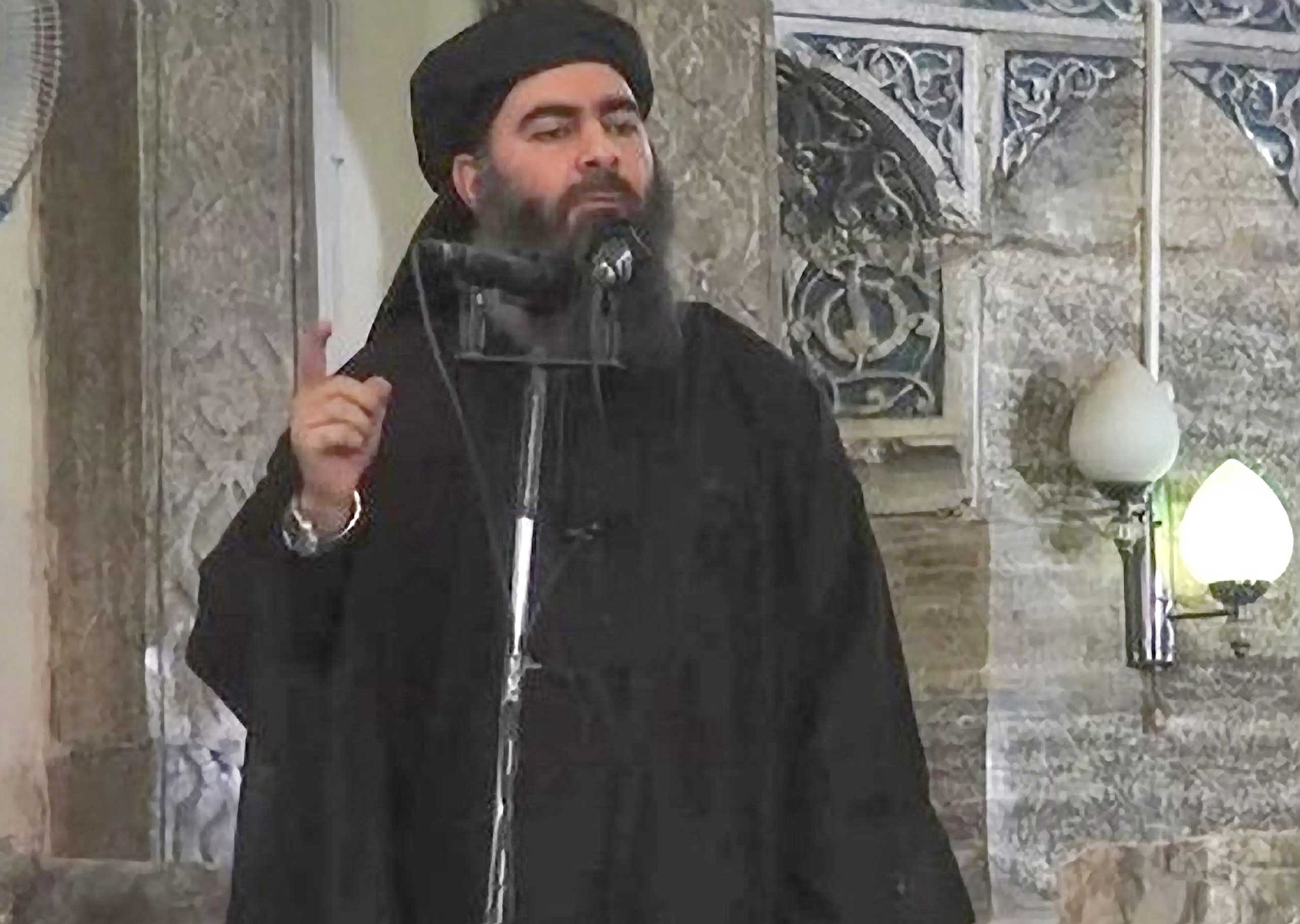 Image purportedly shows the caliph of the self-proclaimed Islamic State, Abu Bakr al-Baghdadi, giving a speech in an unknown location. (EPA)