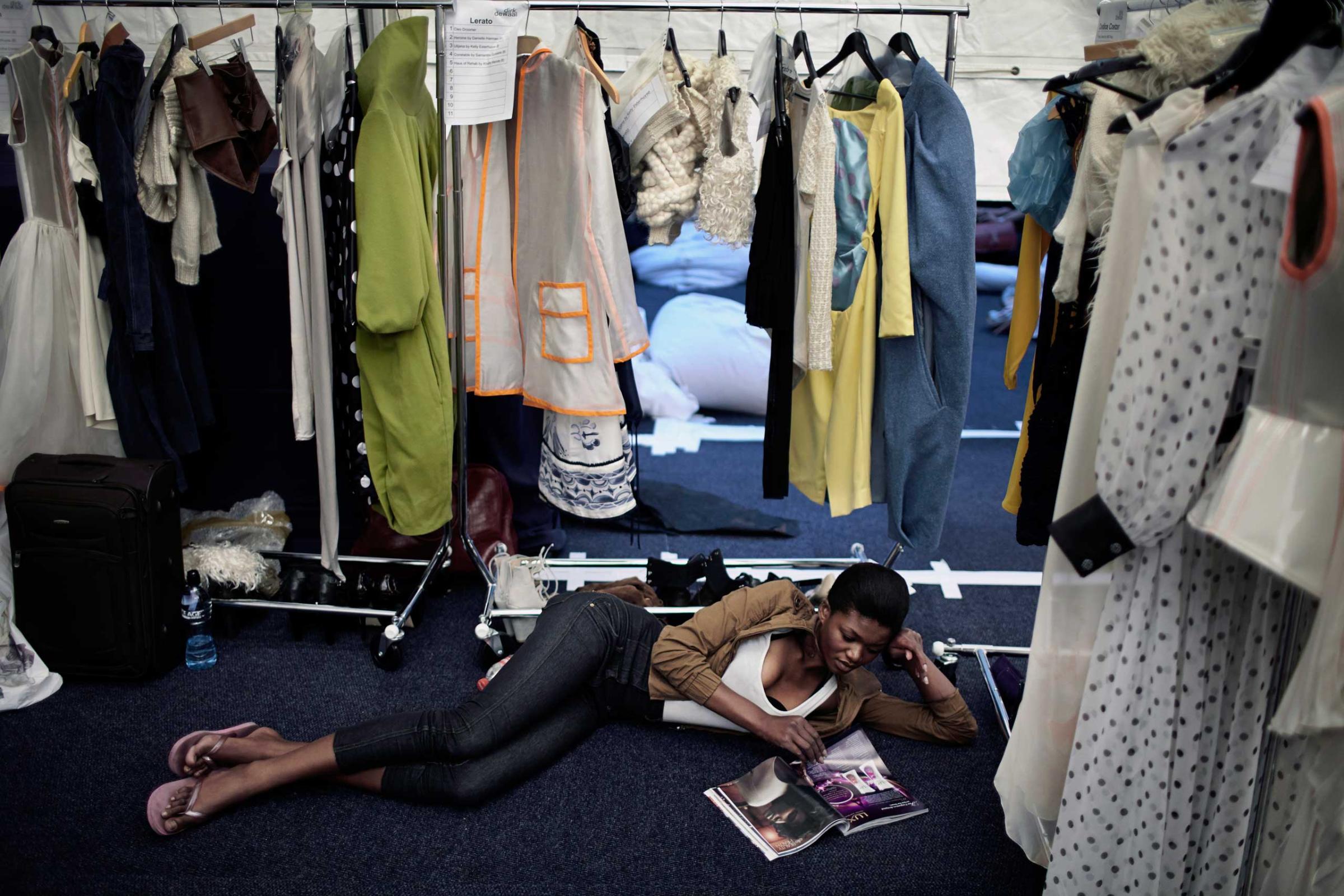 A models reads a fashion magazine backstage before a fashion show at South Africa Fashion Week on Sept. 22, 2011 held in Johannesburg, South Africa.