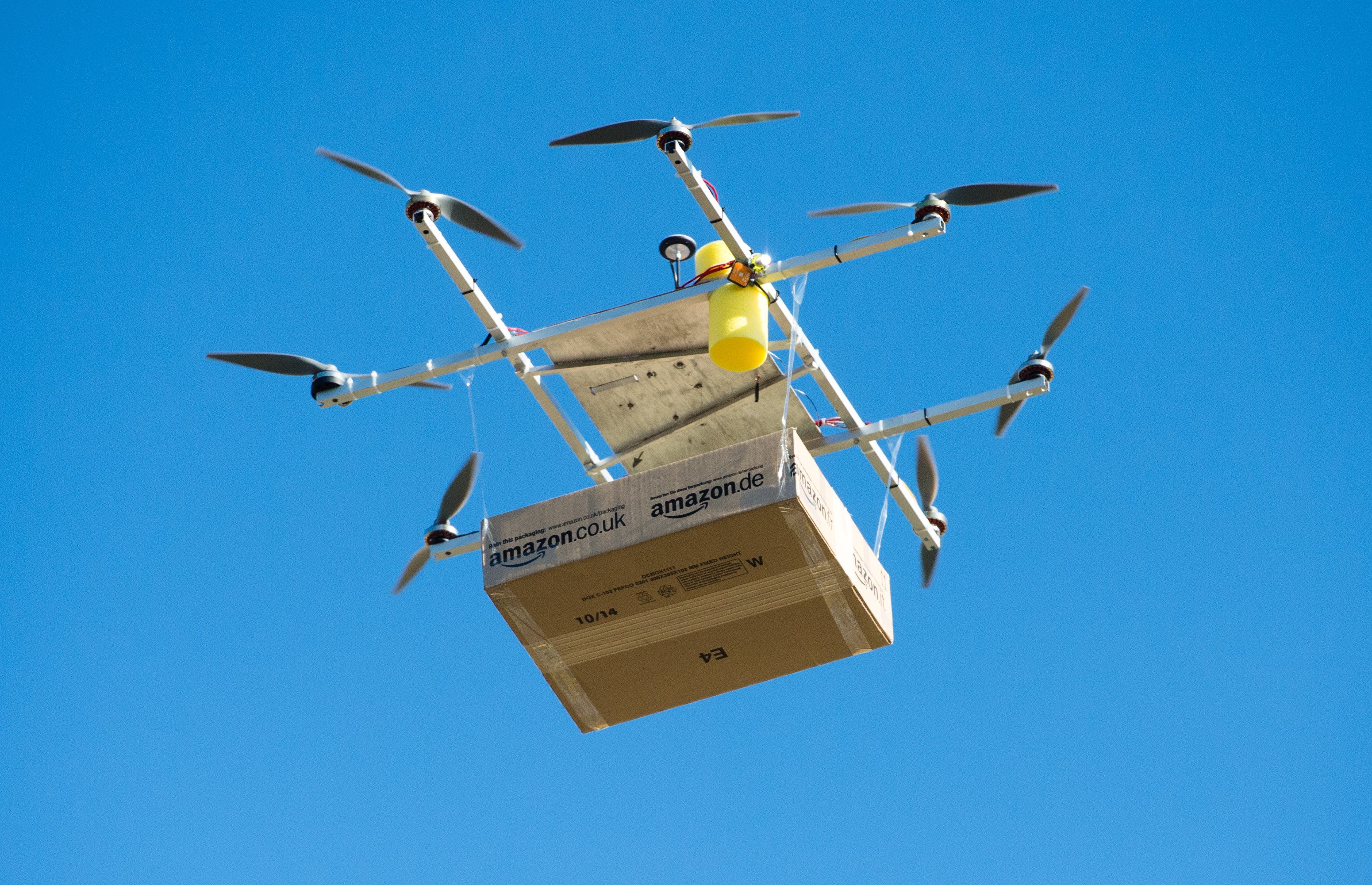 A drone with an Amazon package floats in front of the Amazon logistics center in Leipzig, Germany on Oct 28, 2014. (Peter Endig—dpa/Corbis)