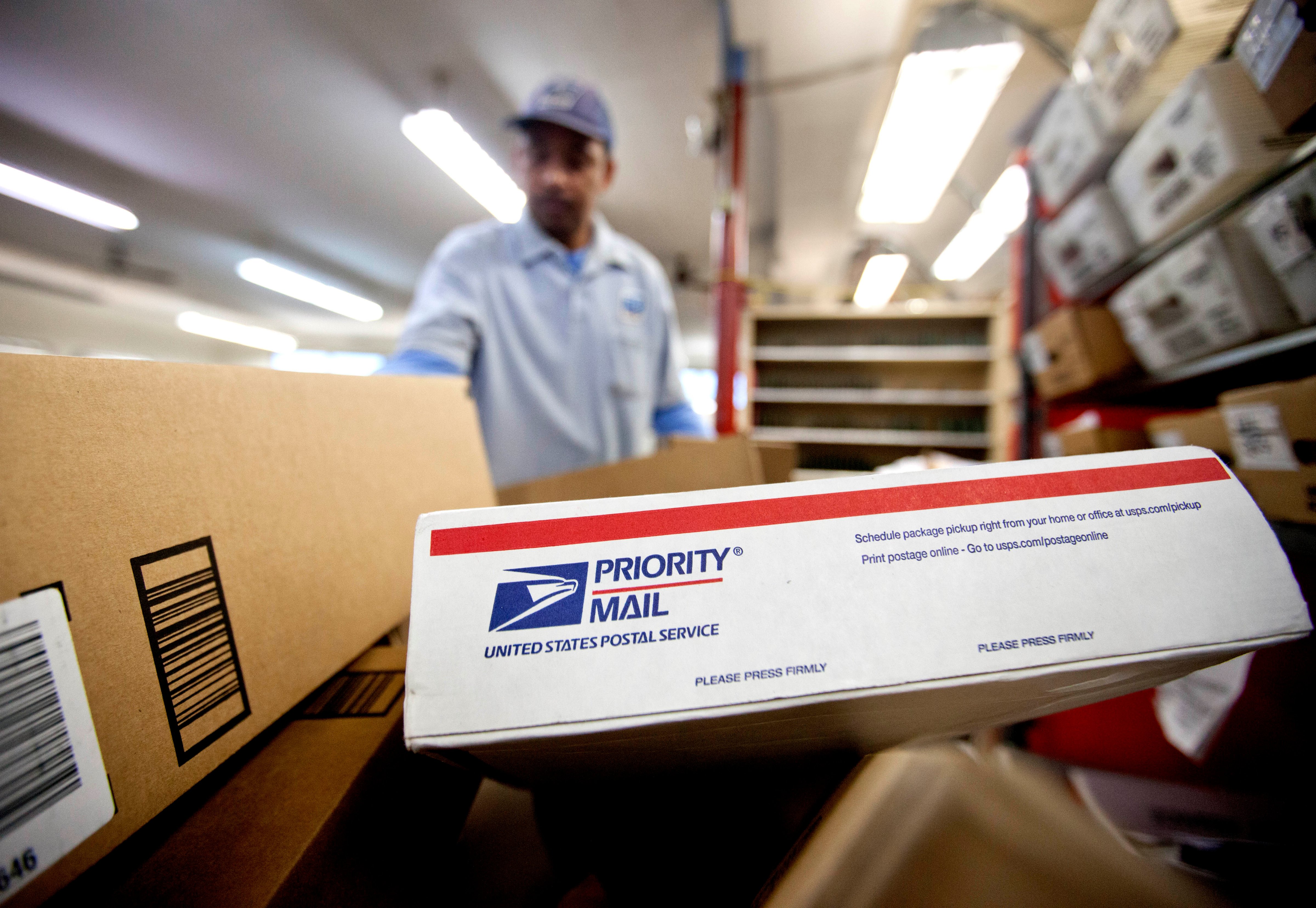 Packages wait to be sorted as a postal worker gathers mail to load into his truck before making a delivery run. The U.S. Postal Service recently announced that it will deliver packages seven days a week through Christmas Day. (David Goldman—AP)