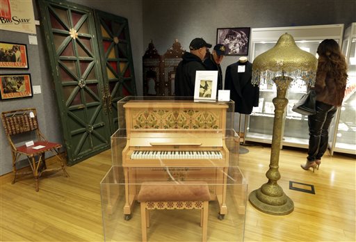 This Nov. 21, 2014 photo shows the piano on which Sam plays "As Time Goes By," a bamboo and cane cafe chair the front doors of Rick's Cafe Americain, and a Moroccan-style painted metal floor lamp from "Casablanca," part of the "There's No Place Like Hollywood" movie memorabilia auction, at Bonhams auction house, in New York. (Richard Drew—AP)