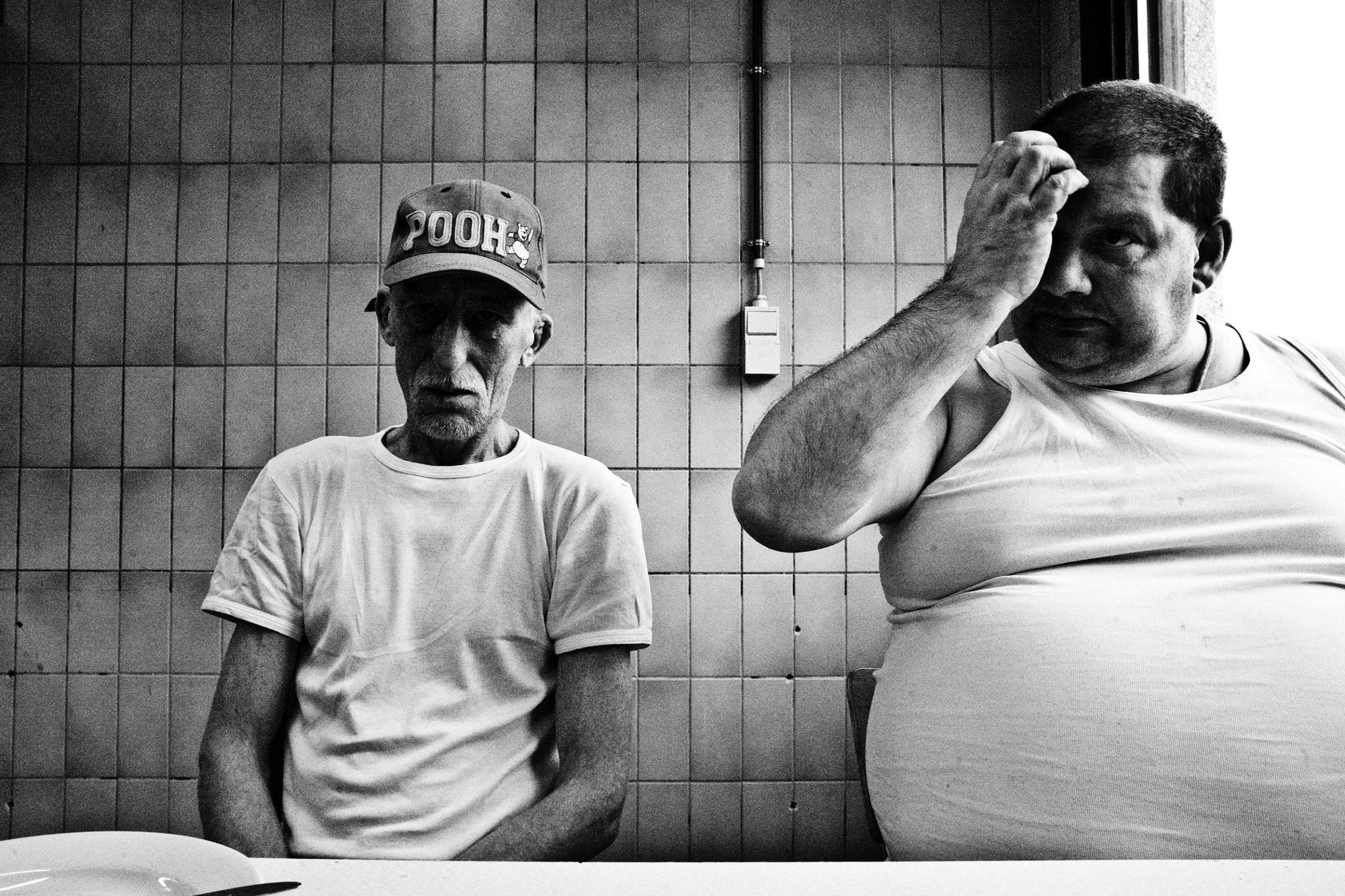 Two inmates eating in the kitchen of the prison of Paifve, Liège, Belgium. March 2011.