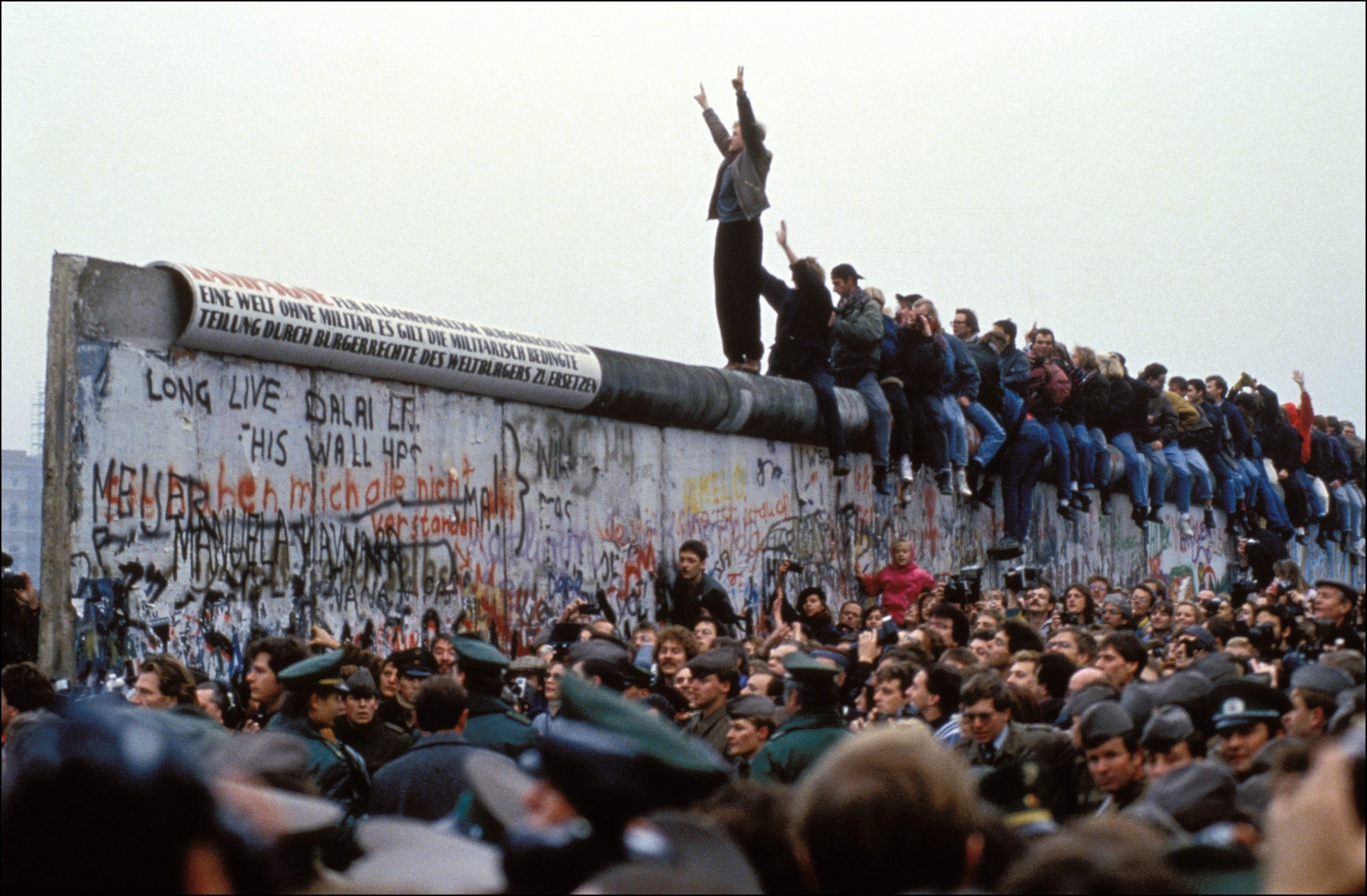 A man celebrates on the Berlin wall on November 12, 1989 in Berlin, Germany. (Pool CHUTE DU MUR BERLIN—Gamma-Rapho via Getty Images)