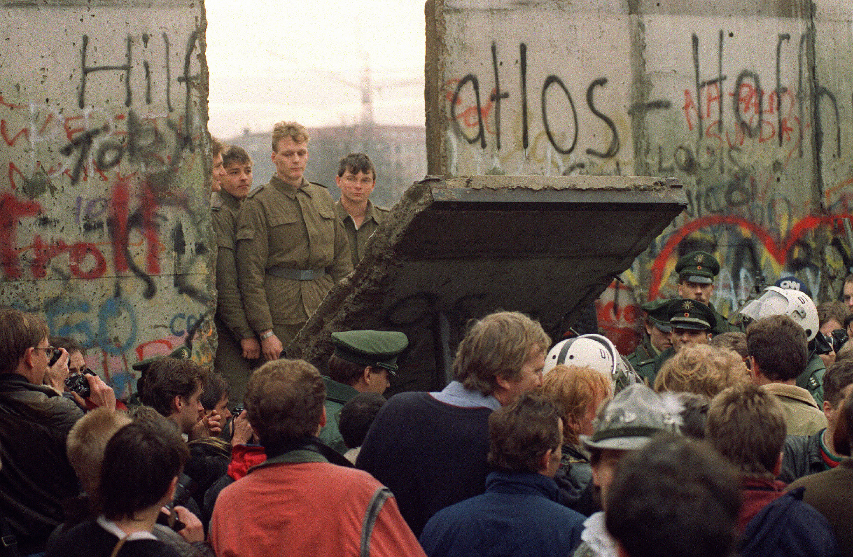 A crowd in front of the Berlin Wall on Nov. 11, 1989 watches border guards demolish a section of the wall in order to open a new crossing point between East and West Berlin in Germany. (AFP—AFP/Getty Images)