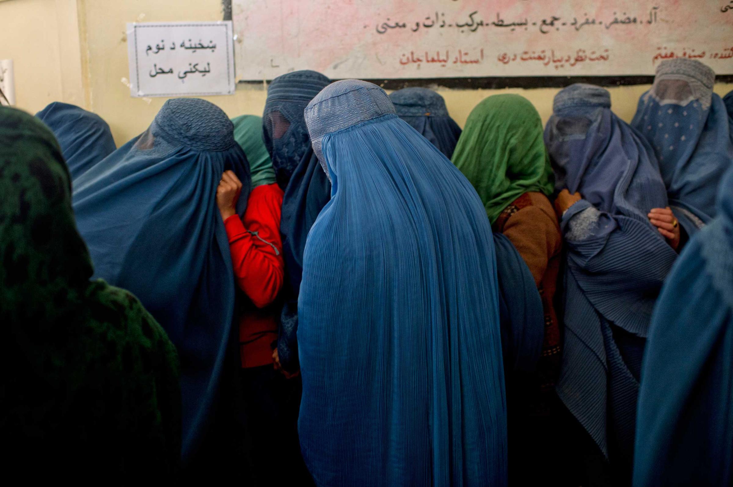 Afghans line up to register to vote for Presidential elections at a center run by the Afghan Independent Electoral Commission in Shah Shaheed, Kabul, Afghanistan, March 25, 2014.