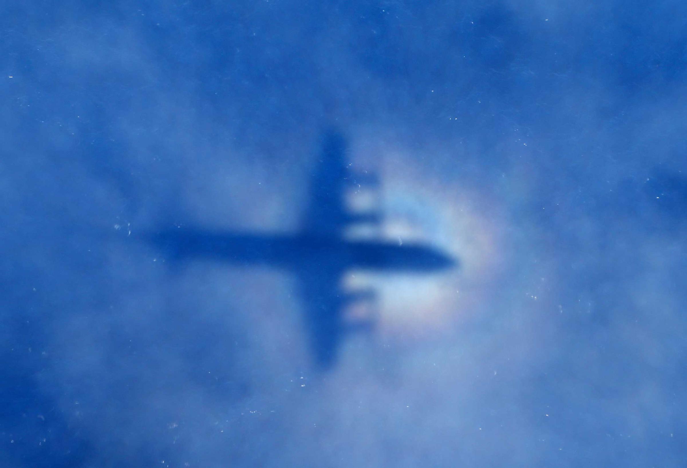 A shadow of a Royal New Zealand Air Force P3 Orion aircraft is seen on low cloud cover while it searches for missing Malaysia Airlines Flight MH370 in Perth, Australia, March 31, 2014.