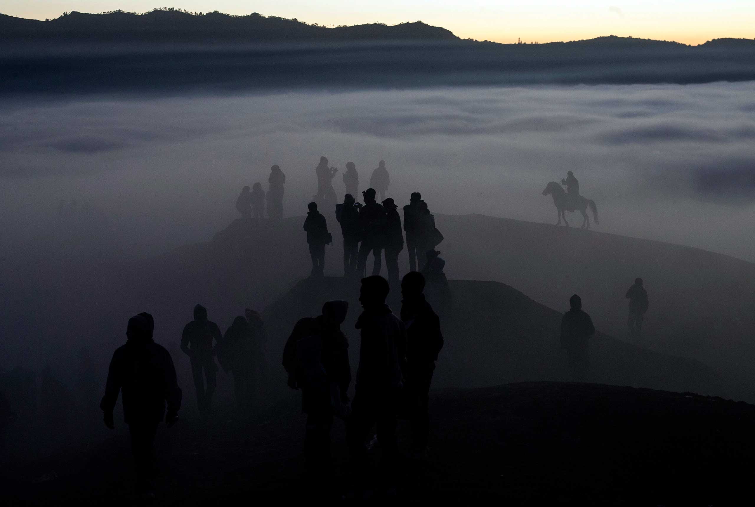Indonesian villagers walk to the crater during the Kasodo ceremony at Mount Bromo, Probolinggo, Indonesia, Aug. 12, 2014.
