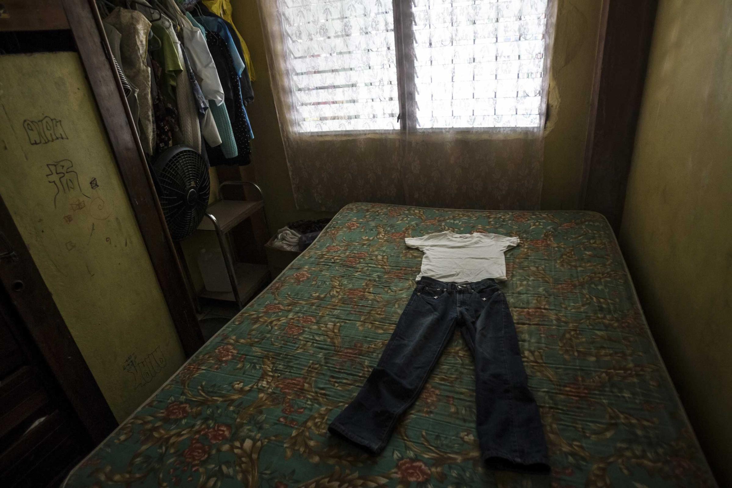 Clothes laid out on a bed for seven-year-old Kenneth Castellanos, whom police say was tortured to death by gang members in San Pedro Sula, Honduras, May 23, 2014.