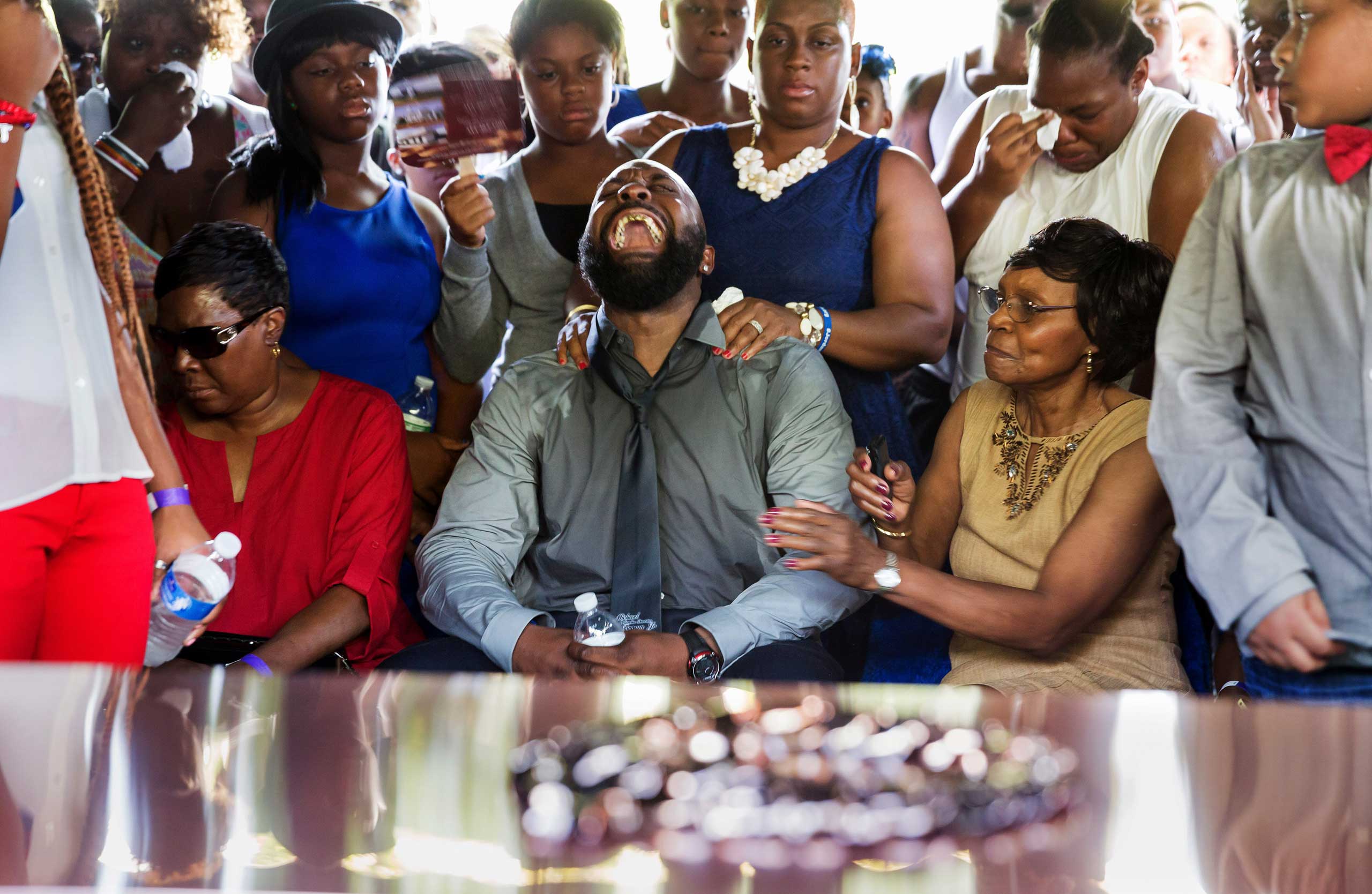 An anguished Michael Brown, Sr. yells as his son's casket is lowered into the ground at St. Peter's Cemetery in St. Louis, Mo., on Aug. 25, 2014.