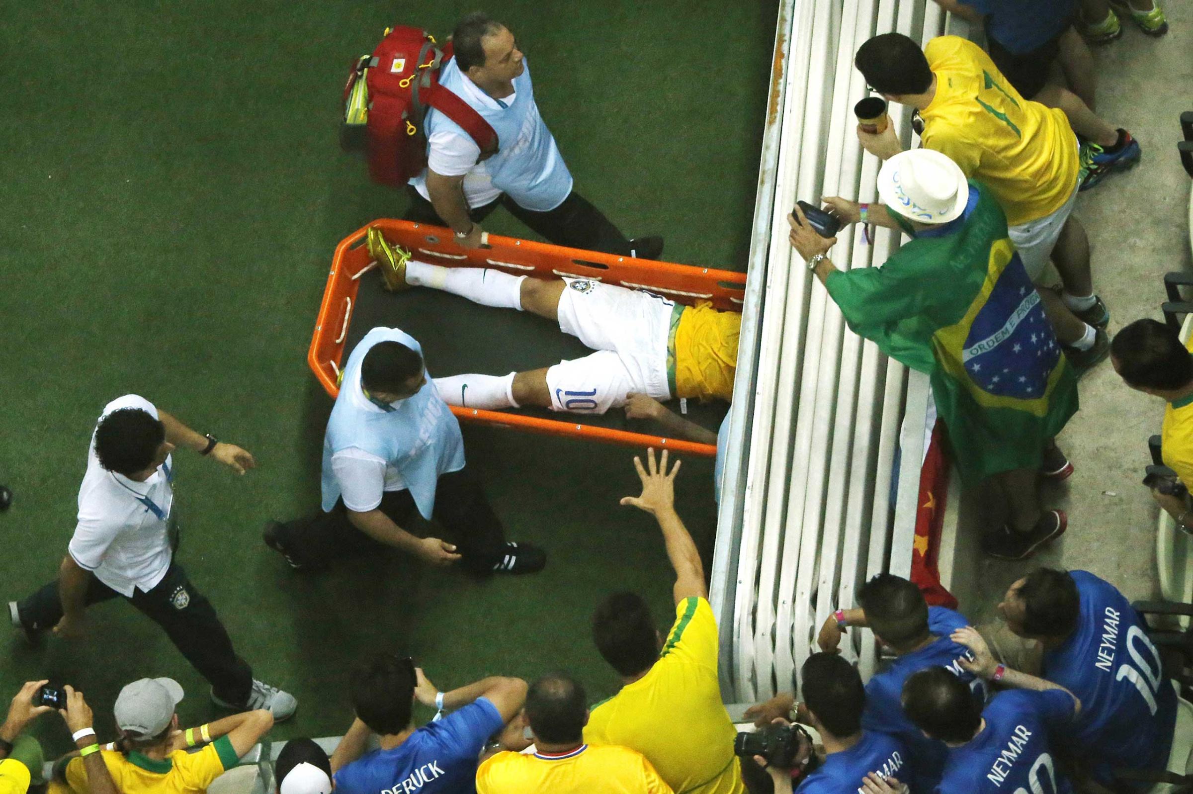 Fans react as Brazil's forward Neymar is carried off the pitch on a stretcher after being injured during the quarter-final football match between Brazil and Colombia at the Castelao Stadium in Fortaleza during the 2014 FIFA World Cup, July 4, 2014.