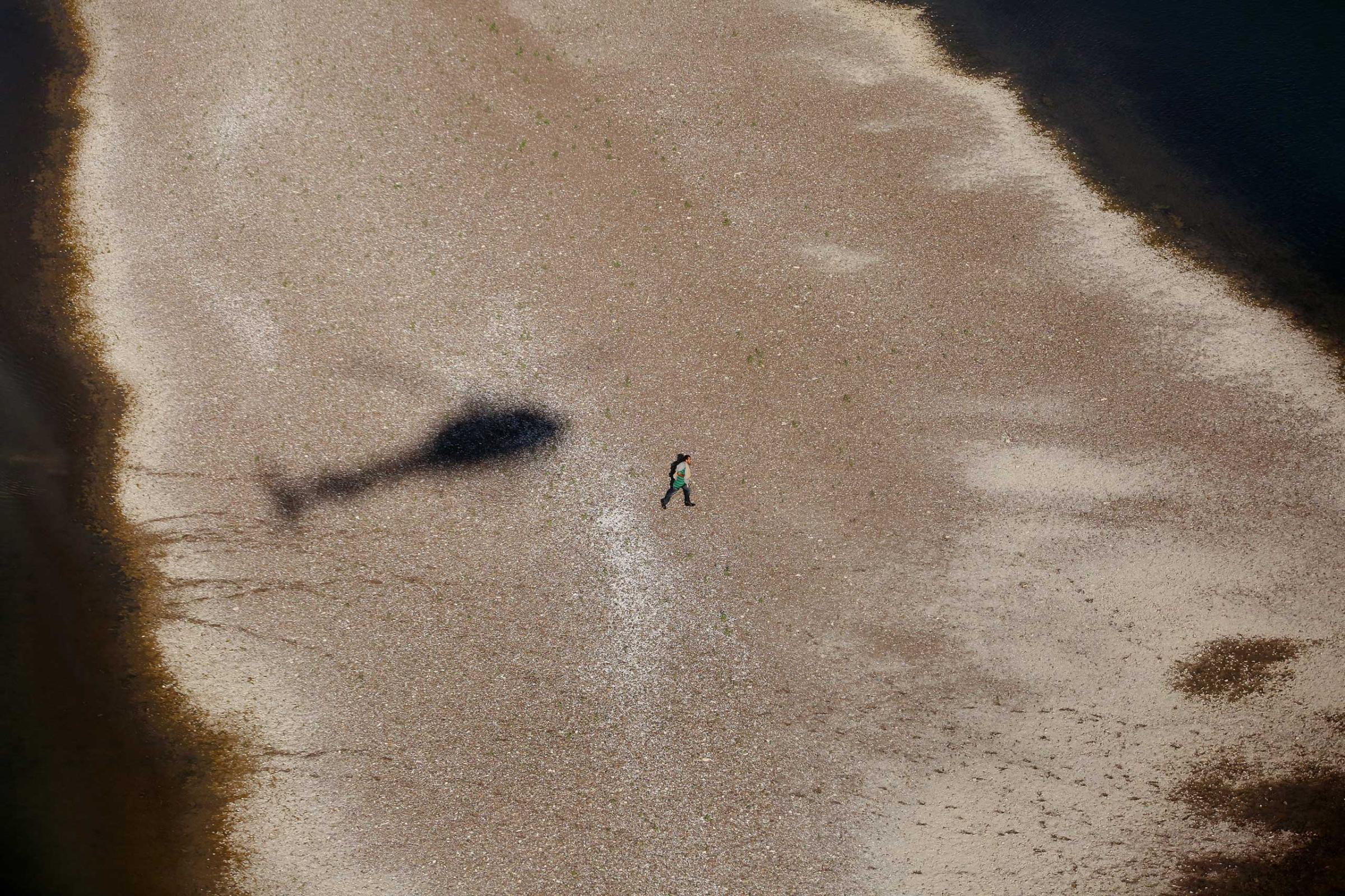 A suspected migrant runs back to Miguel Aleman, Mexico after being pursued by agents near Roma, Texas, Oct. 8, 2014.