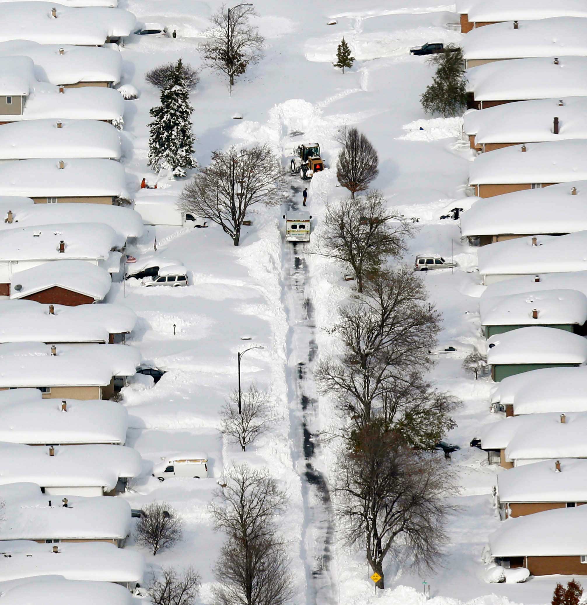 A bulldozer clears the way for an ambulance in a neighborhood in West Seneca, N.Y. on Nov. 19, 2014.