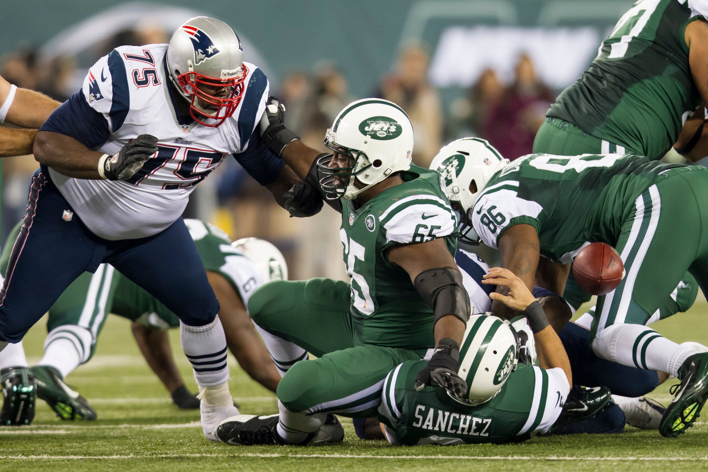 Patriots defensive tackle Vince Wilfork (75) pushes back New York Jets guard Brandon Moore (65) into quarterback Mark Sanchez (6) causing Sanchez to fumble the ball during the NFL Thanksgiving Day game between the New England Patriots and the New York Jets at MetLife Stadium in East Rutherford, N.J on Nov. 22, 2012.
