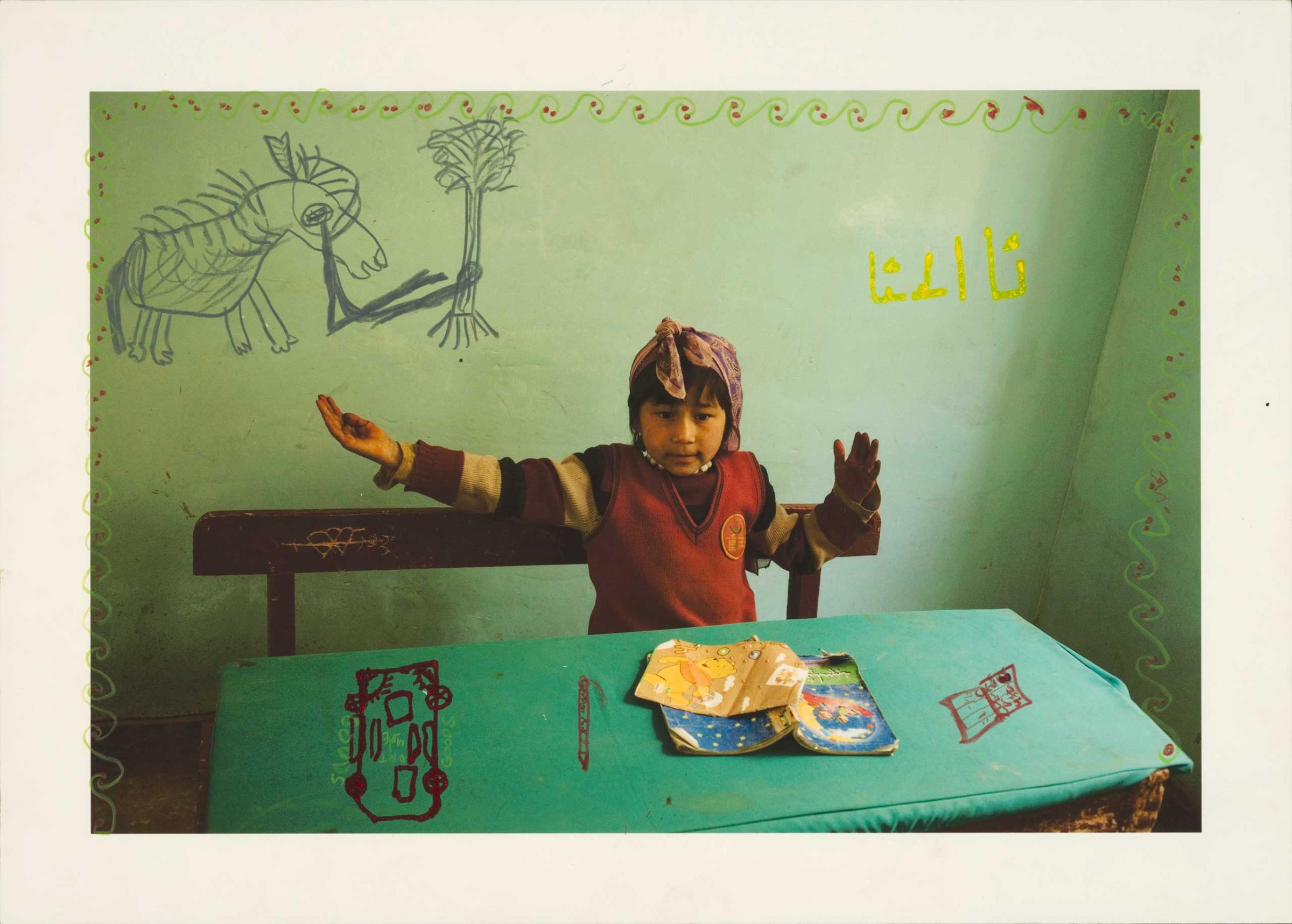 I photographed Guliman learning the Uyghur alphabet at school and returned several years later with this print. She wrote the four versions of the Uyghur letter A on the wall behind her. Her gesture represents the “final A.” 2011