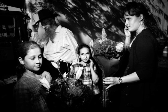 A mother and her two daughthers buys flowers before the beginning of Shabbat on Kingston Avenue, Crown Heights, Brooklyn. October 2010.