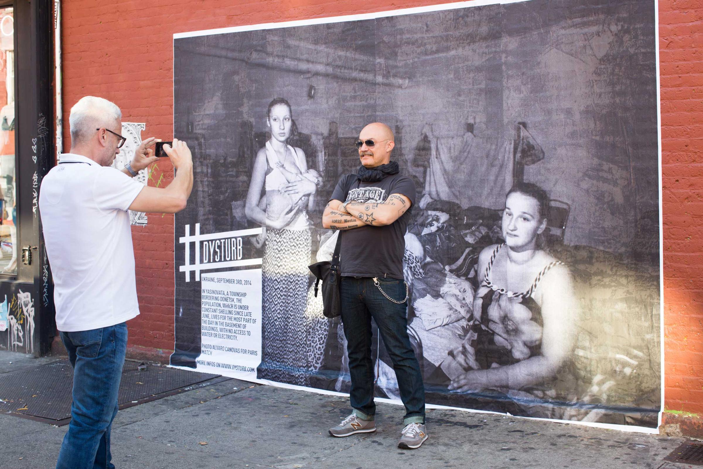 A New Yorker in front of one of Dysturb's photographs (in Brooklyn, on the corner of N 6th Street and Bedford Avenue). October 17th 2014.