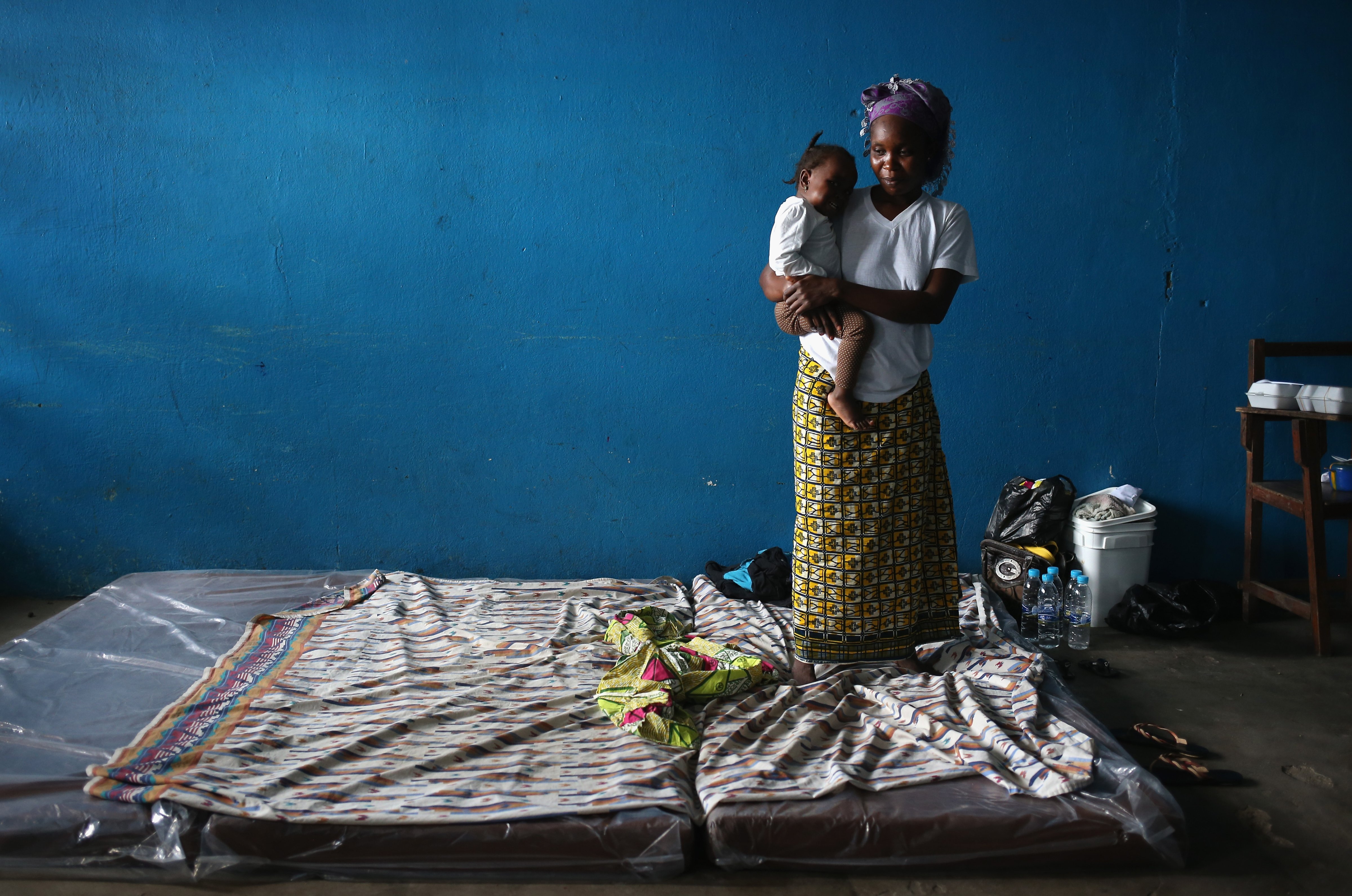 A mother and child stand atop their mattresses in a classroom now used as Ebola isolation ward on Aug. 15, 2014, in Monrovia, Liberia (John Moore—Getty Images)