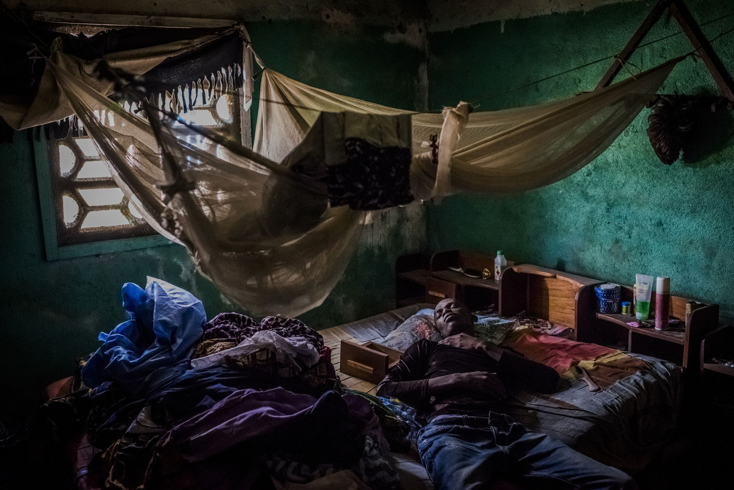 Mark Jerry, who along with his adopted daughter was turned away from an Ebola clinic a day prior, rests at his grandmother?s home in Monrovia, Liberia.
