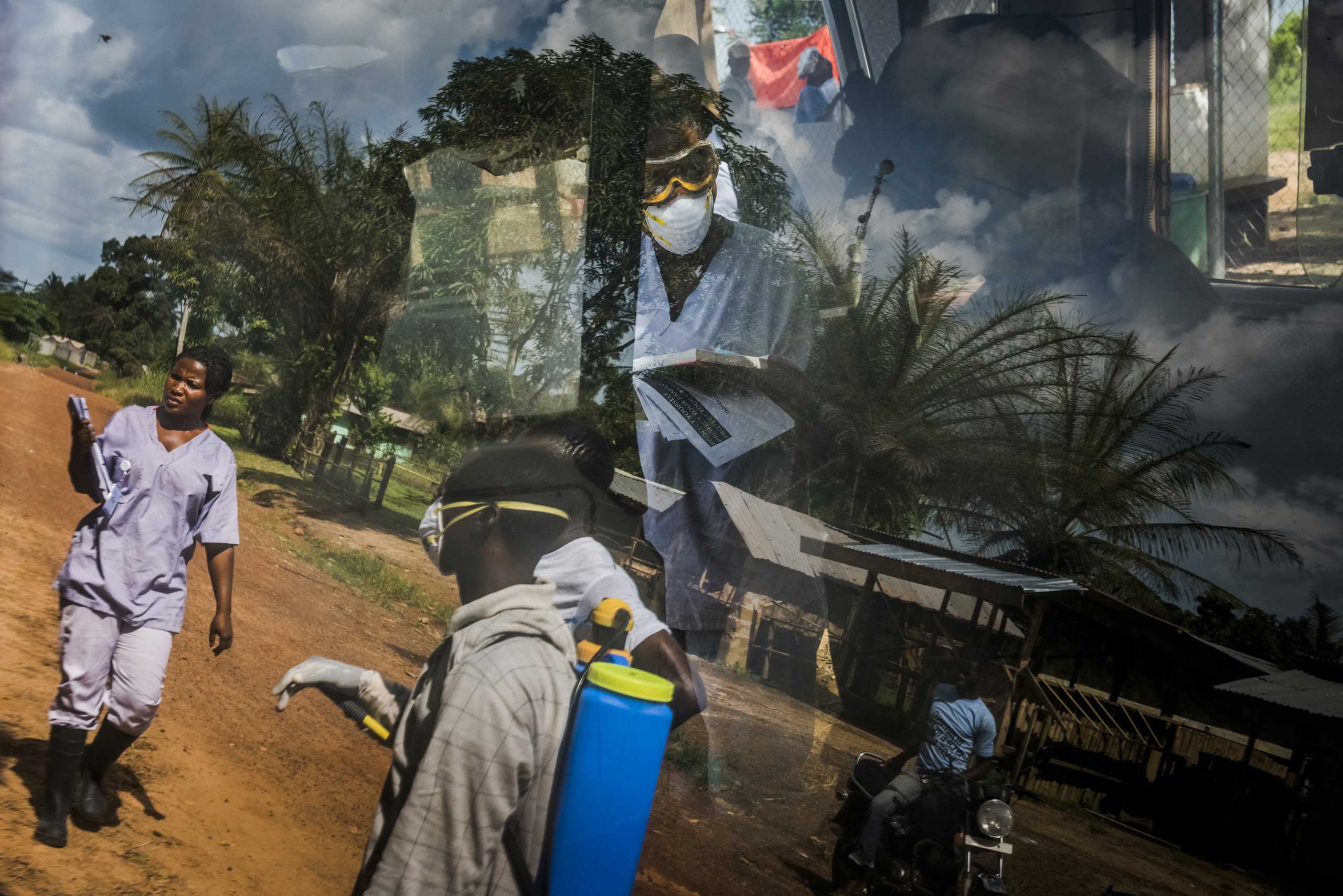 The reflection on an ambulance window of an Ebola outreach team from the Bong County International Medical Corps treatment unit in Kakata, Liberia, Oct. 24, 2014. (Daniel Berehulak—The New York Times/Redux)