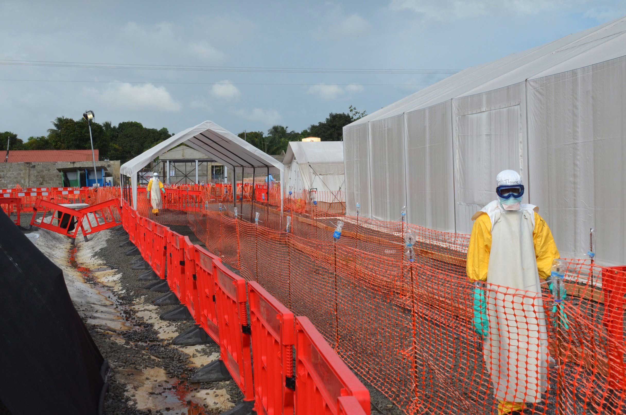 Health workers wearing Personal Protective Equipments (PPE) stand outside an Ebola treatment center run by Medecins Sans Frontieres (Doctors without Borders -- MSF) in Monrovia, Liberia on Oct. 27, 2014. (Zoom Dosso—AFP/Getty Images)