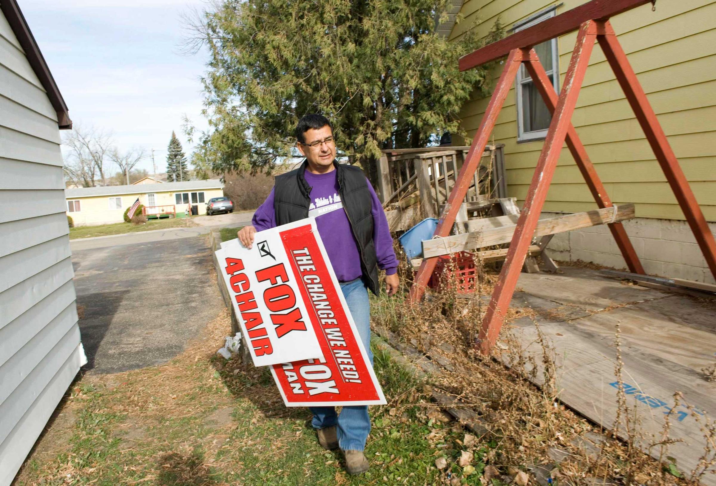 Three Affiliated Tribes council chairman candidate Fox delivers signs to a supporter's house on the Fort Berthold Reservation in North Dakota