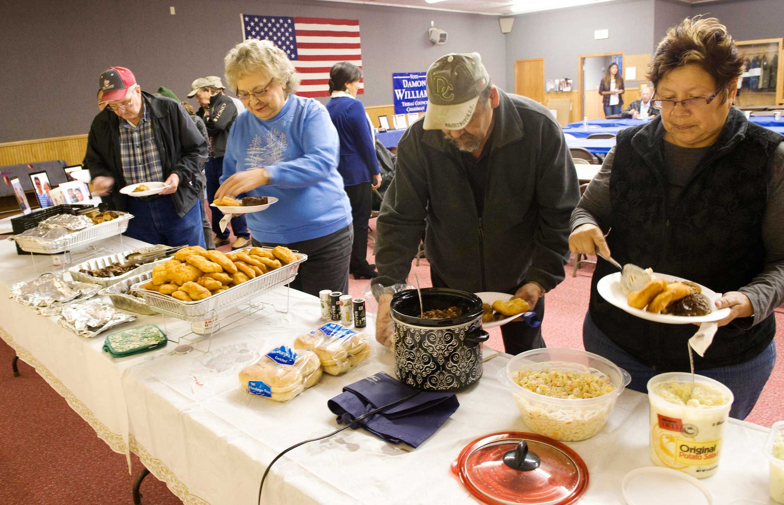 Supporters serve themselves from a buffet during a campaign dinner for Three Affiliated Tribes council chairman candidate Damon Williams on the Fort Berthold Reservation in N.D. on Nov. 1, 2014.