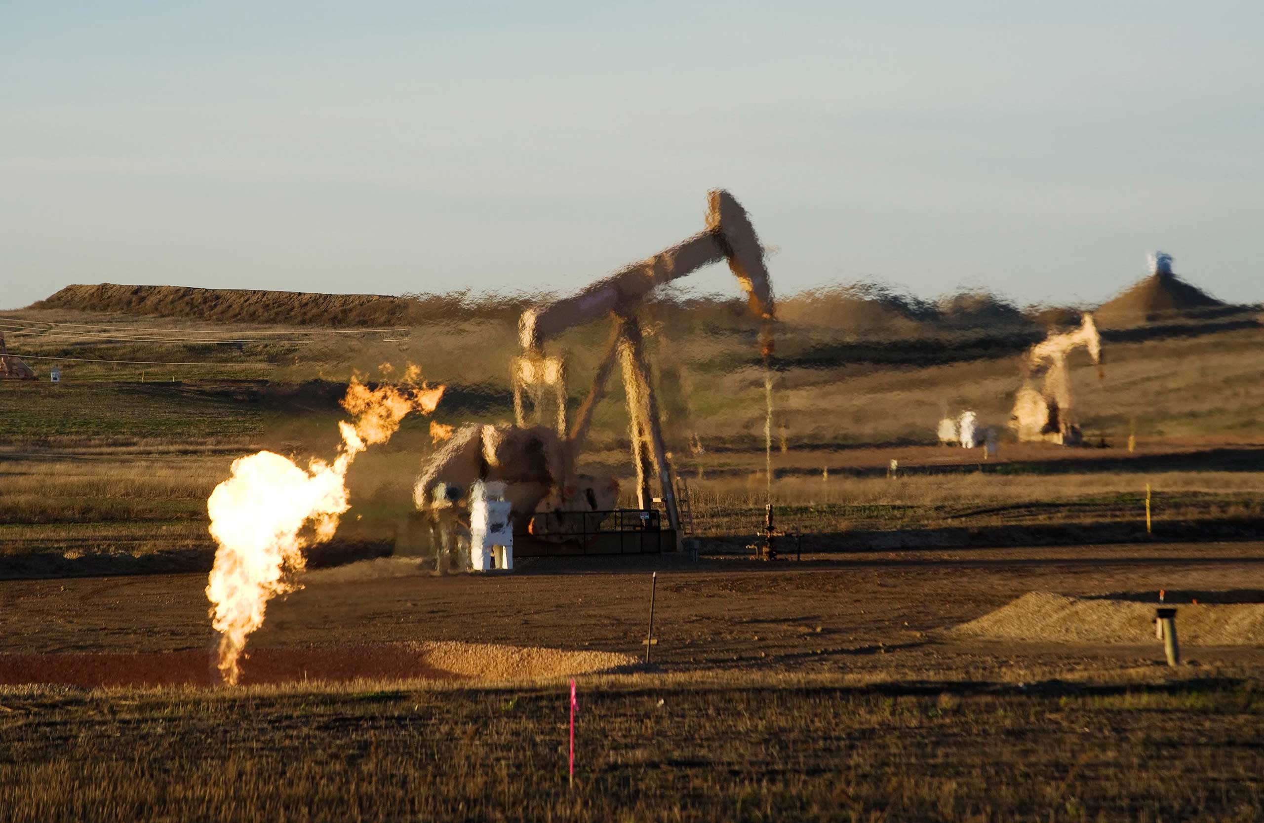 A flare and pump jacks are seen at an oil well on the Fort Berthold Reservation in N.D. on Nov. 1, 2014.
