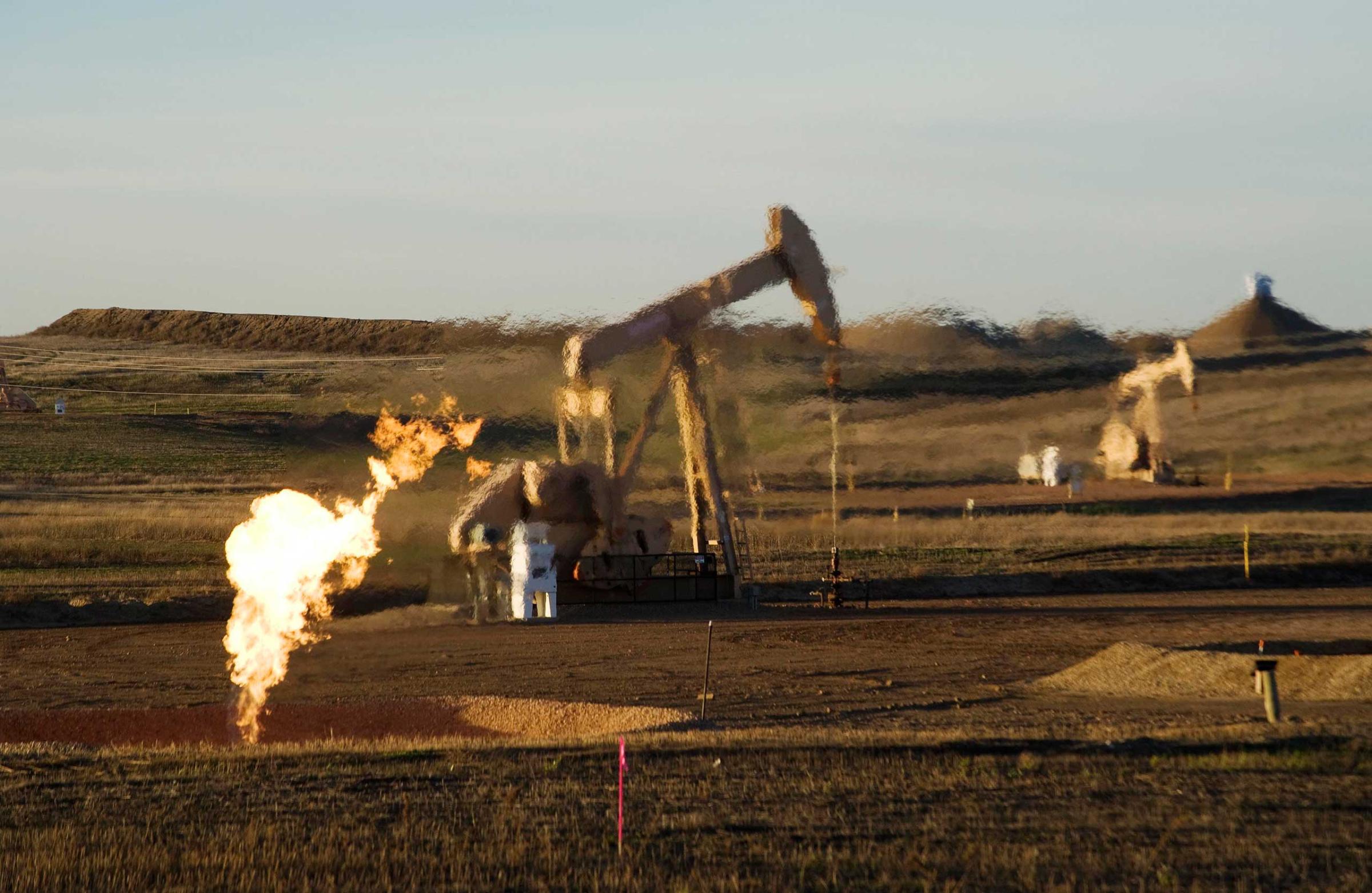 A flare and pump jacks are seen at an oil well on the Fort Berthold Indian Reservation in North Dakota