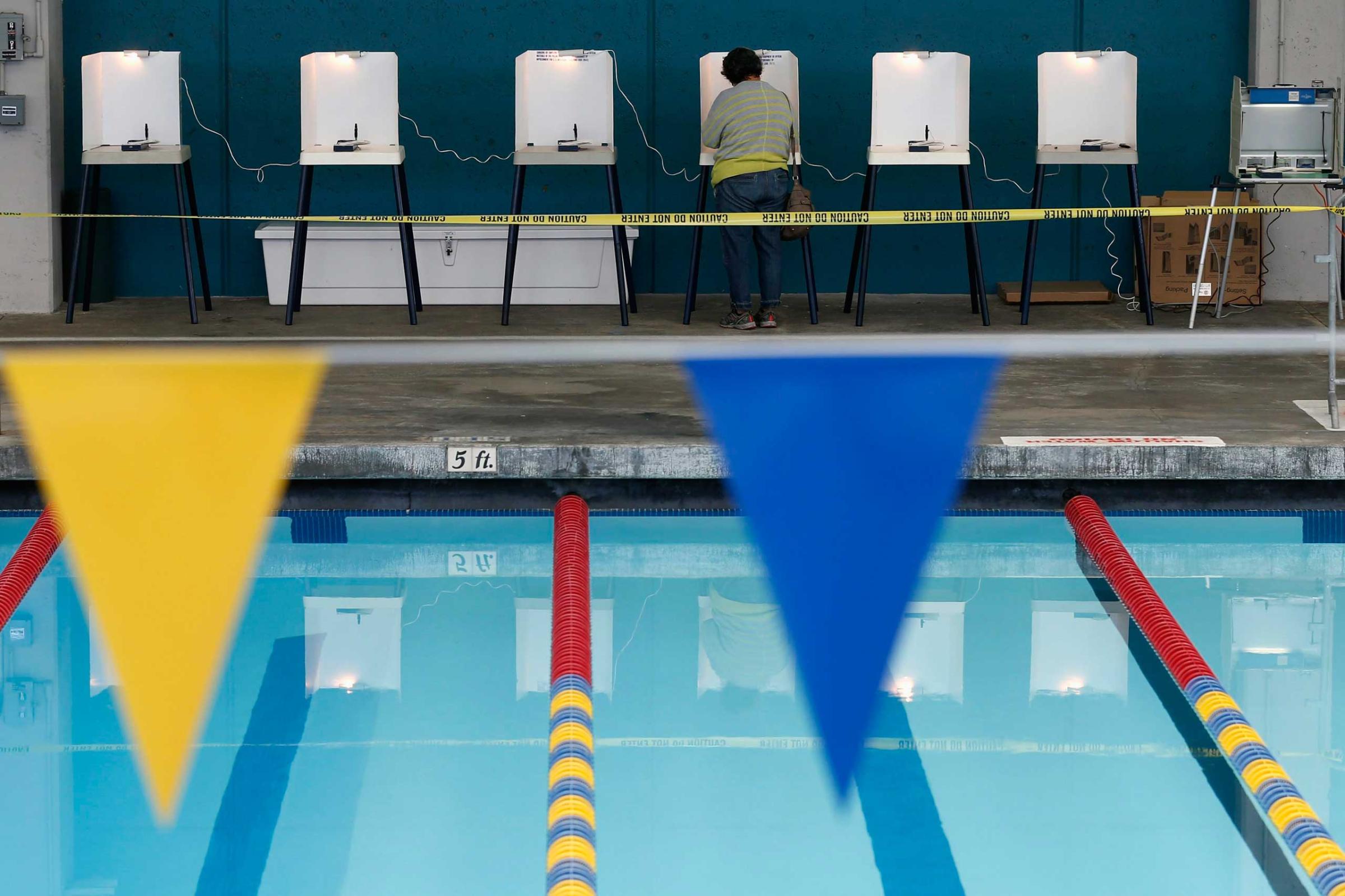 A woman fills out her ballot at a polling place at a swimming pool on Election Day in Los Angeles